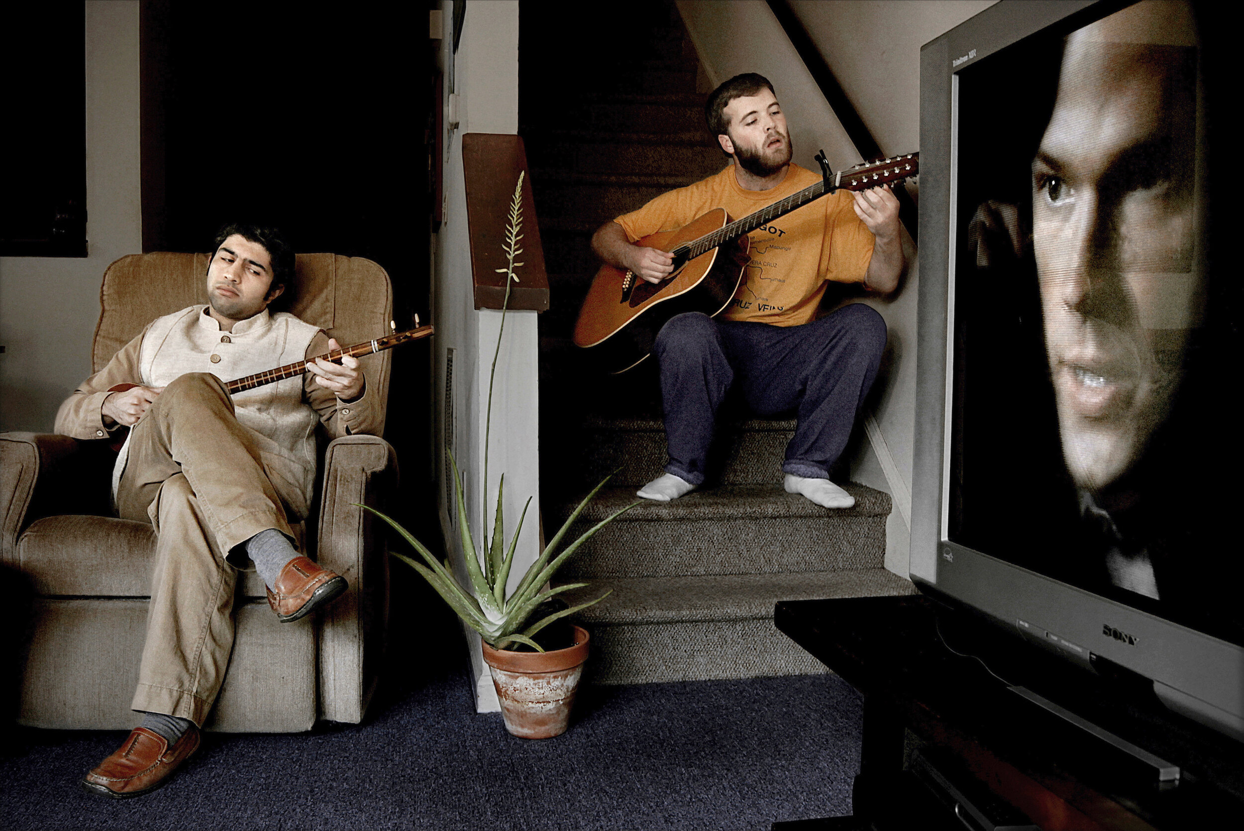   USA. Chapel Hill, NC. 2011. Ali Kadivar [left] plays a setar as his friend, Lukas Sherry, joins him at their apartment. Ali, an Iranian, said, “The image that the Western media presents of Iran, as conservative, backward, and homogeneous, is distor