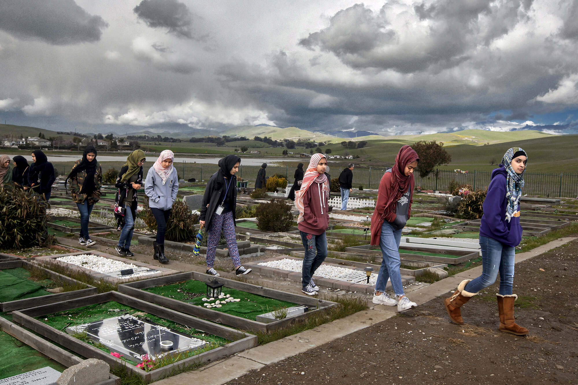   USA. Livermore, California. 2018. A group of female students walk around the Five Pillars Farm Islamic graveyard during a lecture titled, 'Visit to the Graveyard &amp; Gravesite Reminders'. The lecture was taught by a renowned Islamic scholar, Imam