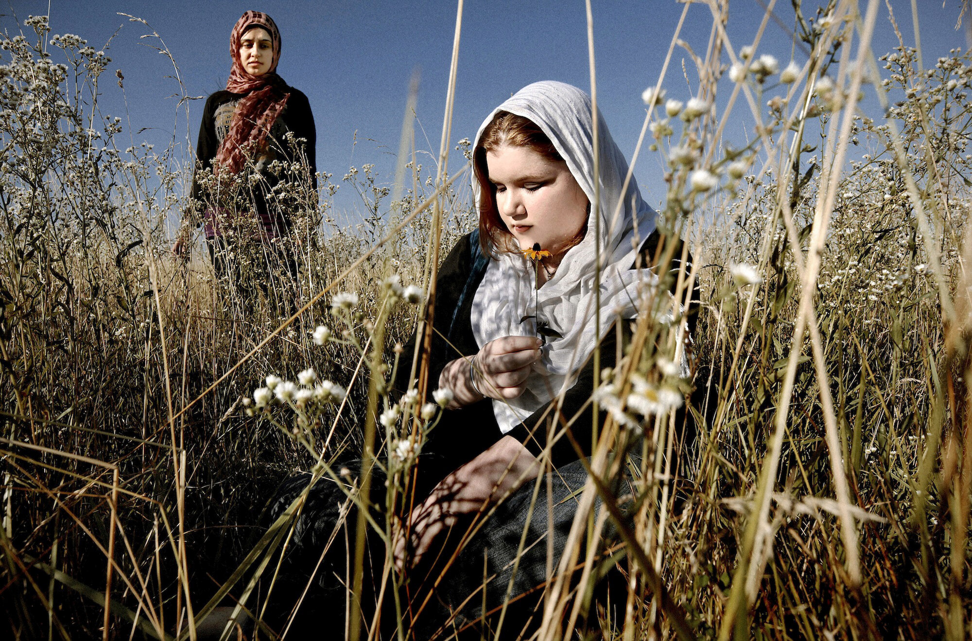   USA. Columbia, Missouri. 2010. Caitlyn Green [right], and her friend photographed in a field. Caitlyn lives in a small town and converted to Islam more than two years ago. But her catholic mother and relatives do not accept her conversion. Caitlyn 