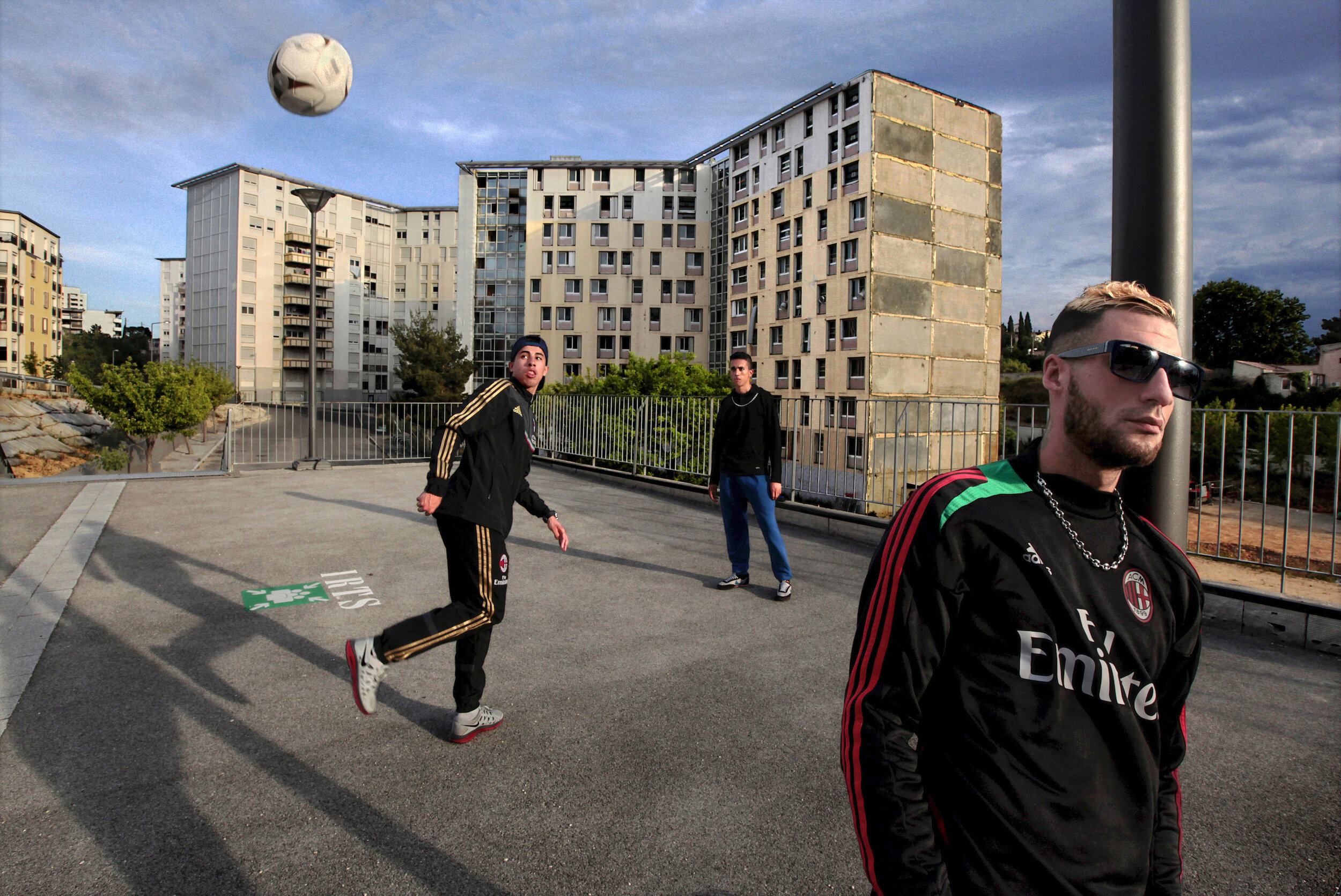   France. Marseille. 2014. Young men honing their soccer skills outside a social service office at cité les Flamants in the 14th arrondissement. This neighborhood has been identified as one of the fourteen sites for the Marseille Urban Renovation pro