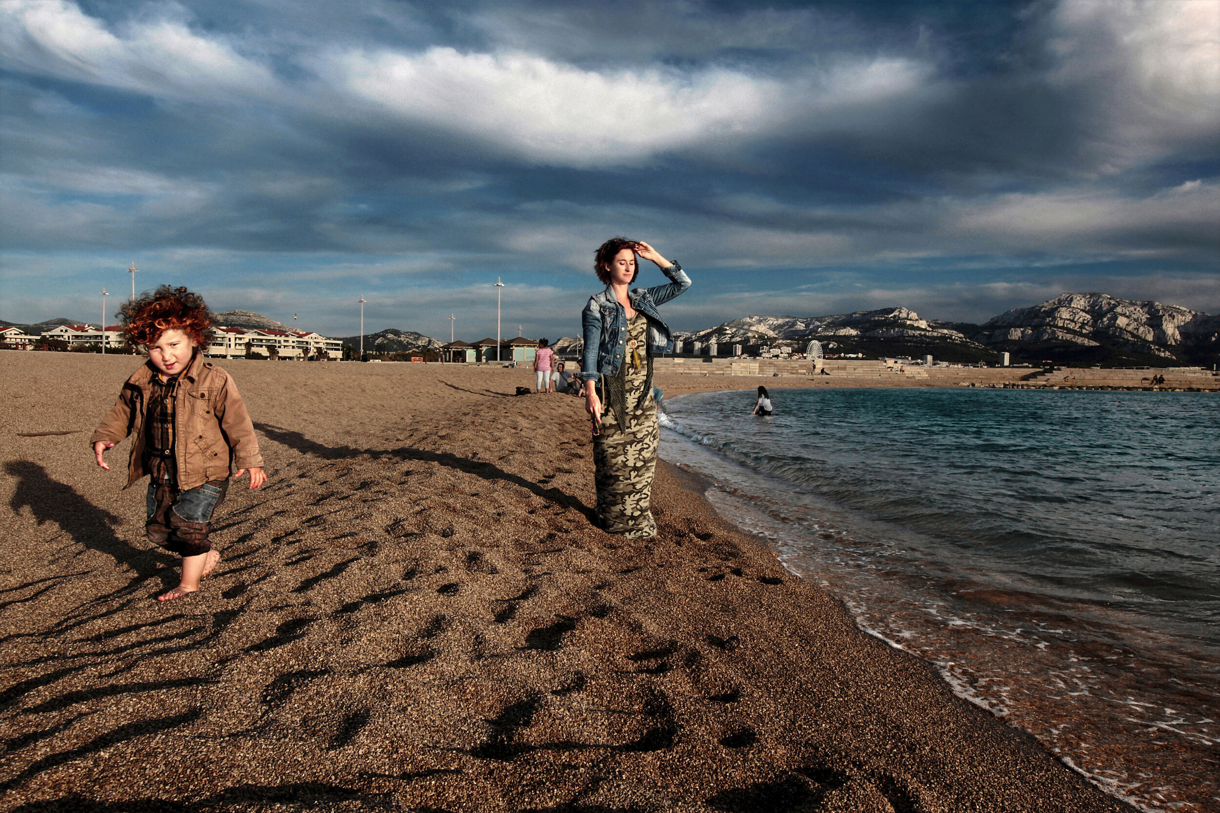   France. Marseille. 2014. Leslie Diebel, with her son Adam Belaadi (left), soaks up the sun at the beach near Promenade Georges Pompidou.            