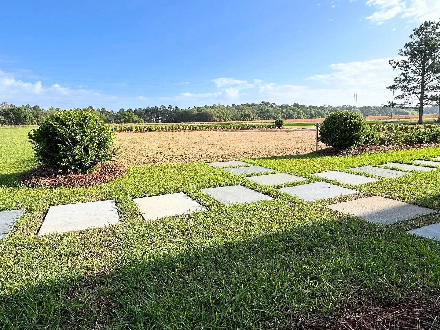 Bluestone steppers, cobble aprons, and grey rubble borders make this new motor court have an old-world feel.