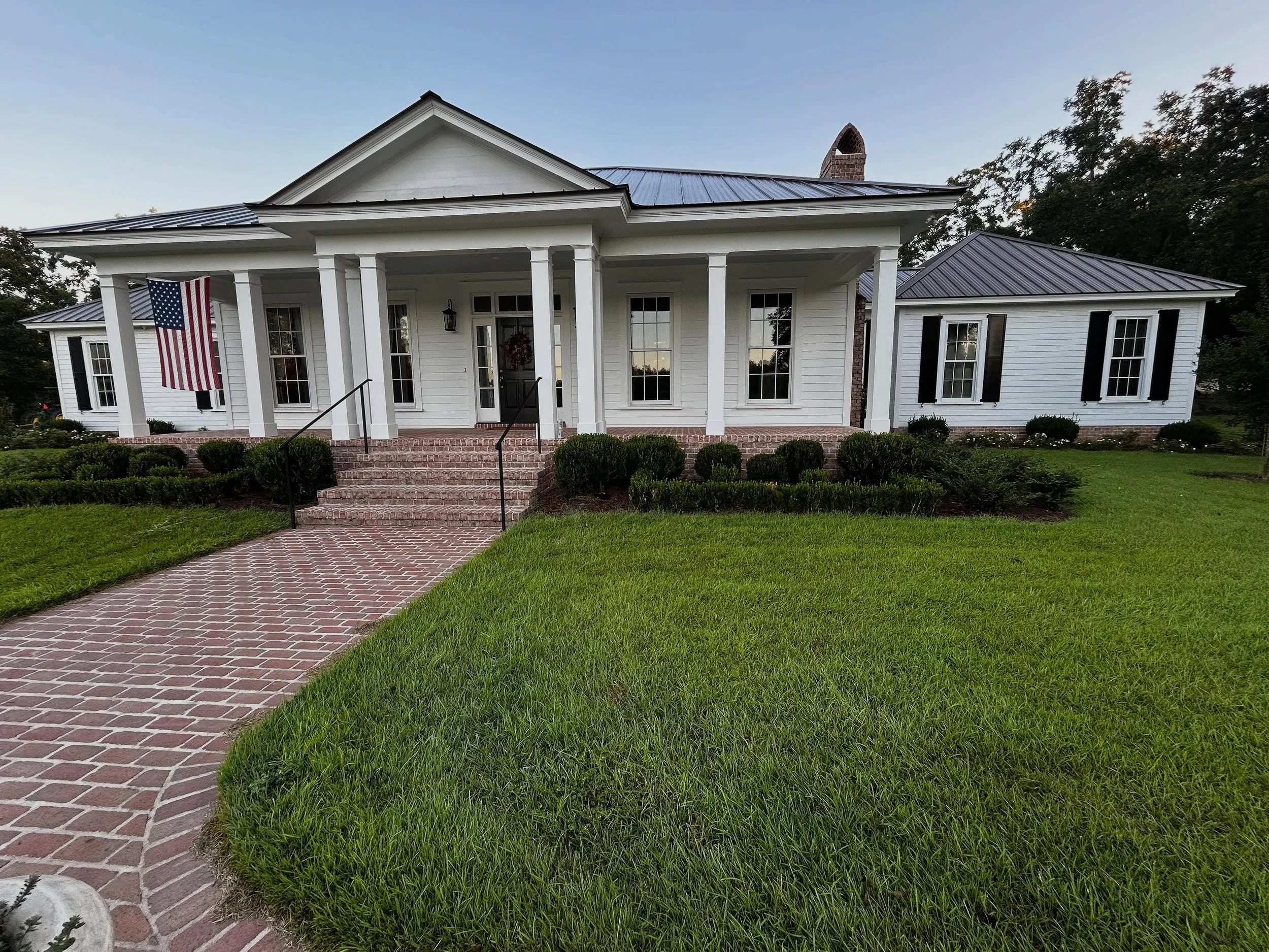 This Creole-inspired home nestled amongst mature pecan trees is landscaped with a classical planting scheme. As the landscape continues to mature the home and garden will become one.
