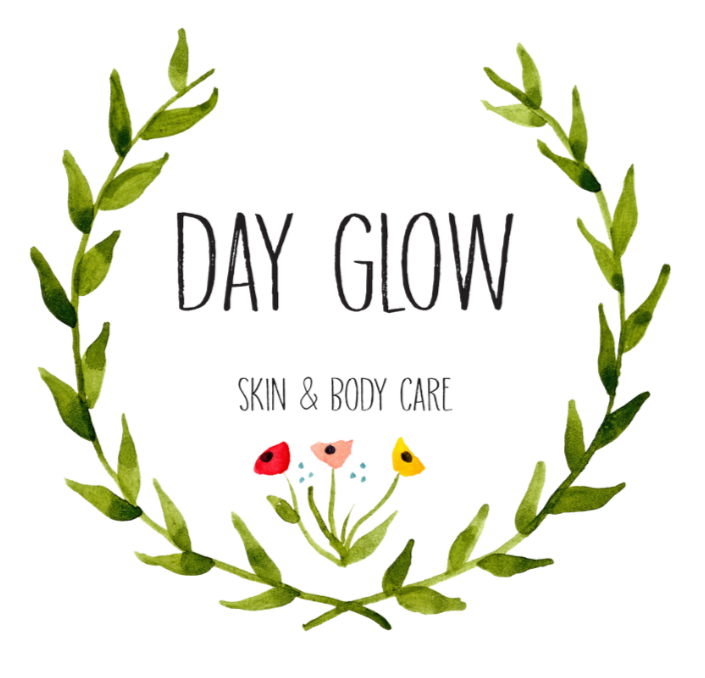 Green leafy laurel wreath surrounding the text "DAY GLOW SKIN & BODY CARE" with small colorful flowers at the bottom center.