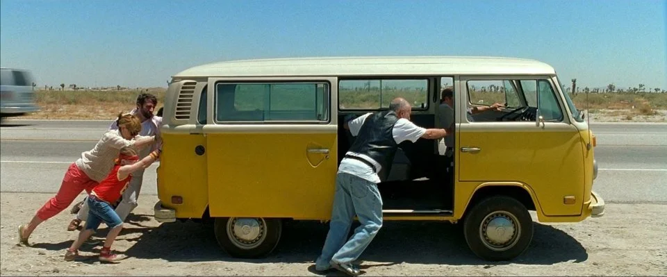 Everyone working together to push the van in Little Miss Sunshine.