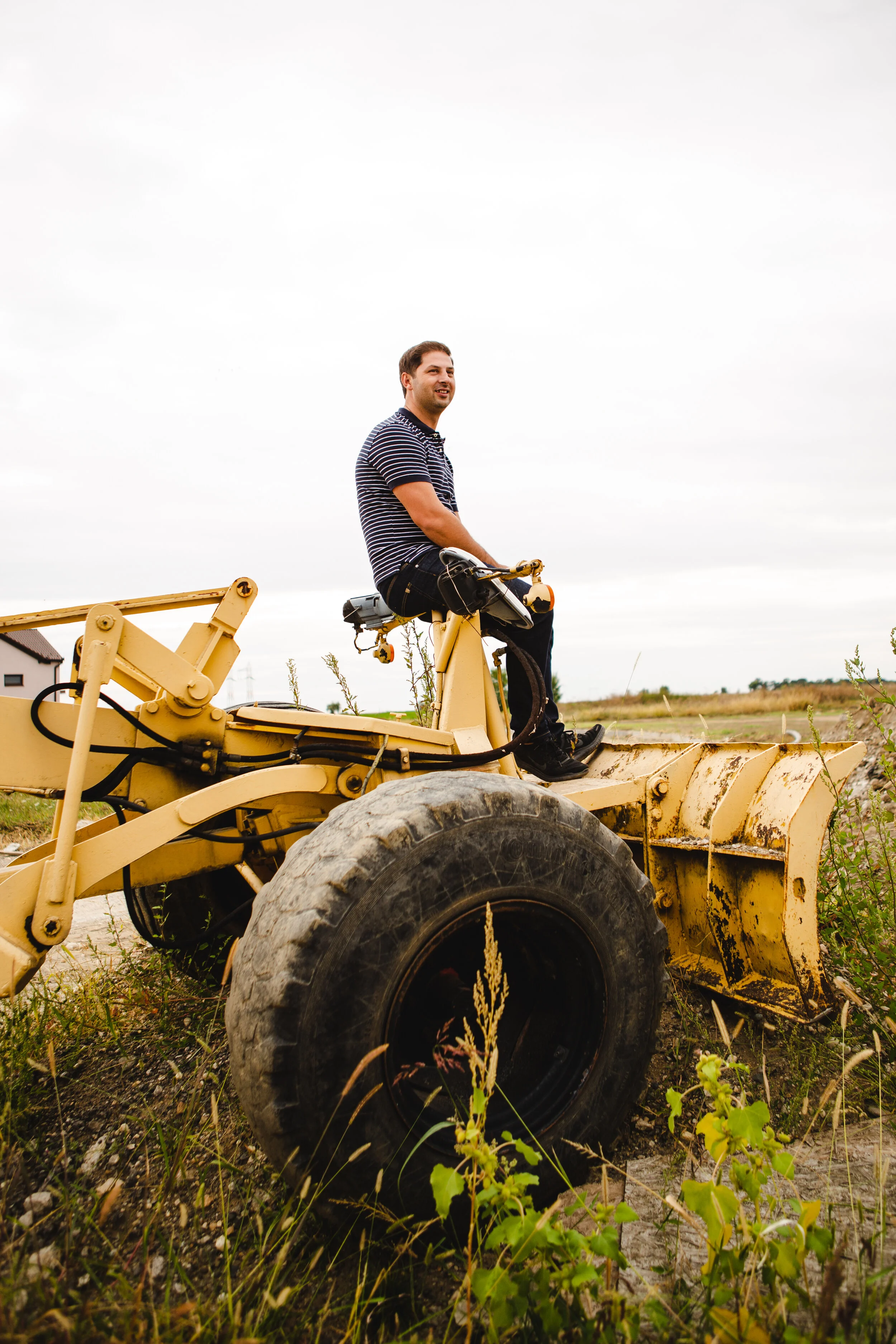 Emmanuel perched atop the first tractor they purchased in their real estate development.