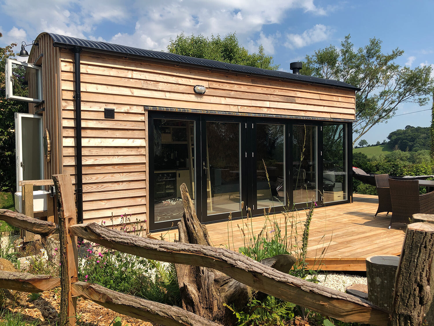 Luxury timber built cabin with Rationel glazed doors sunny deck and landscaped garden