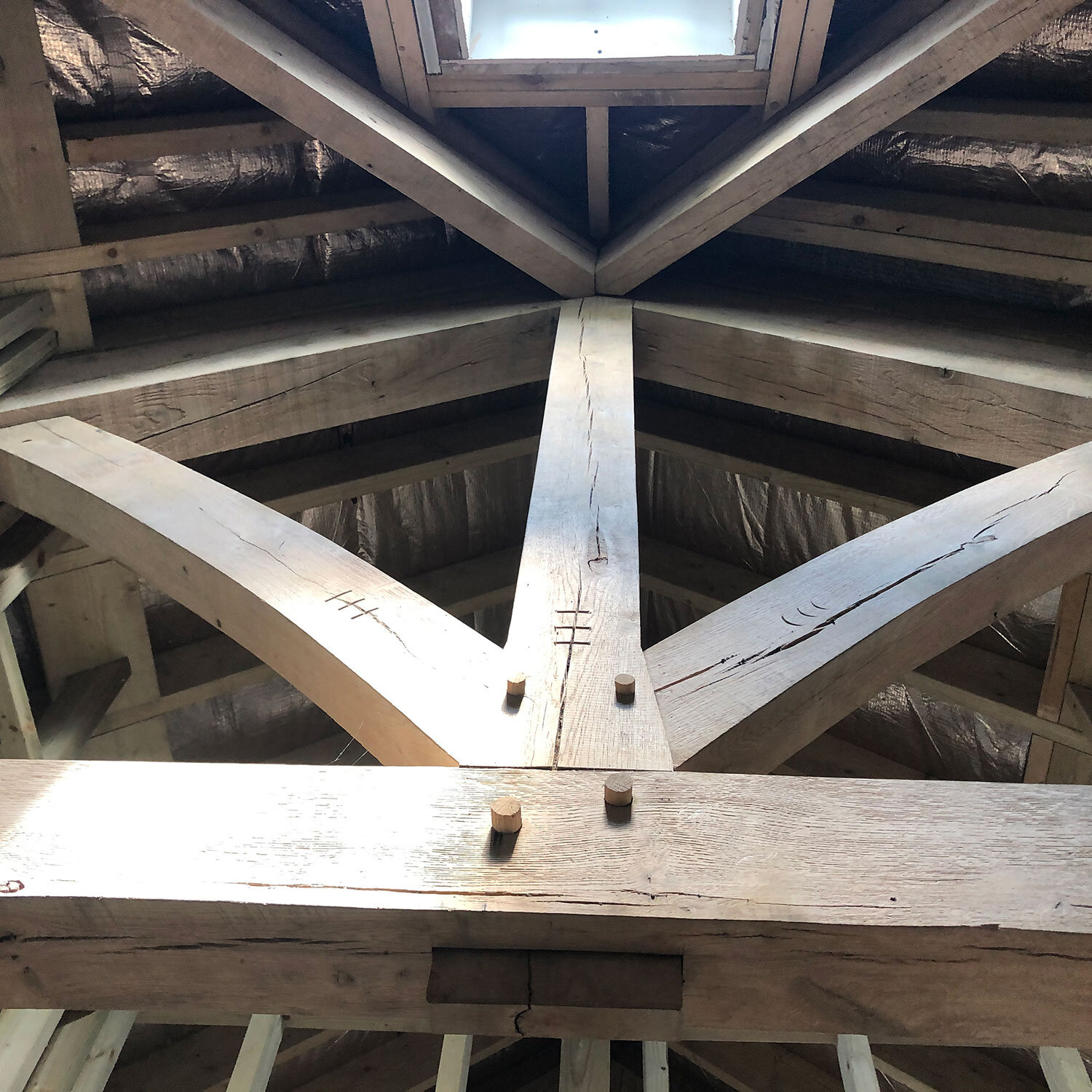 Close-up of pegged timber truss with insulation