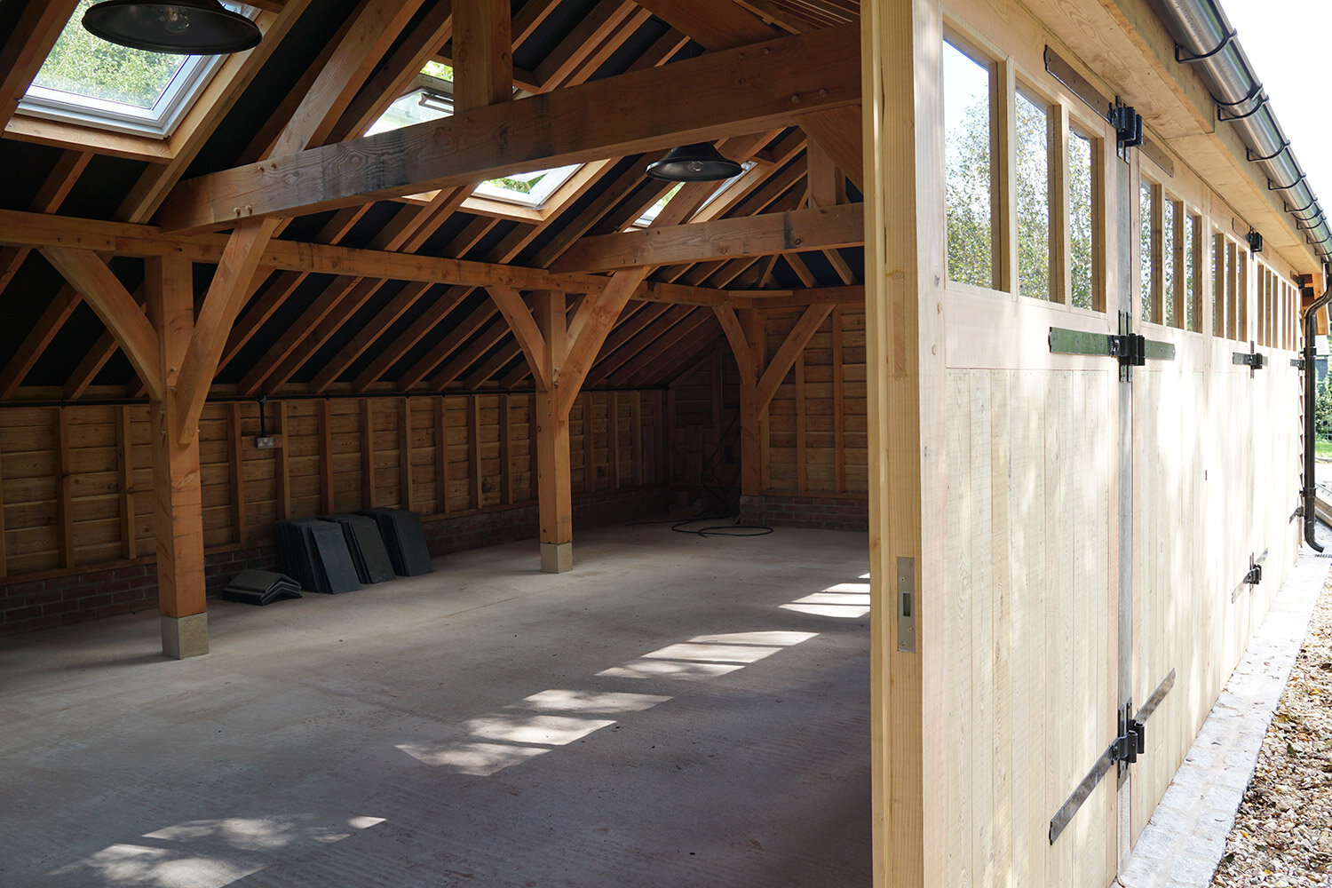 Timber-framed-garage-building-large-doors-open-to-garden