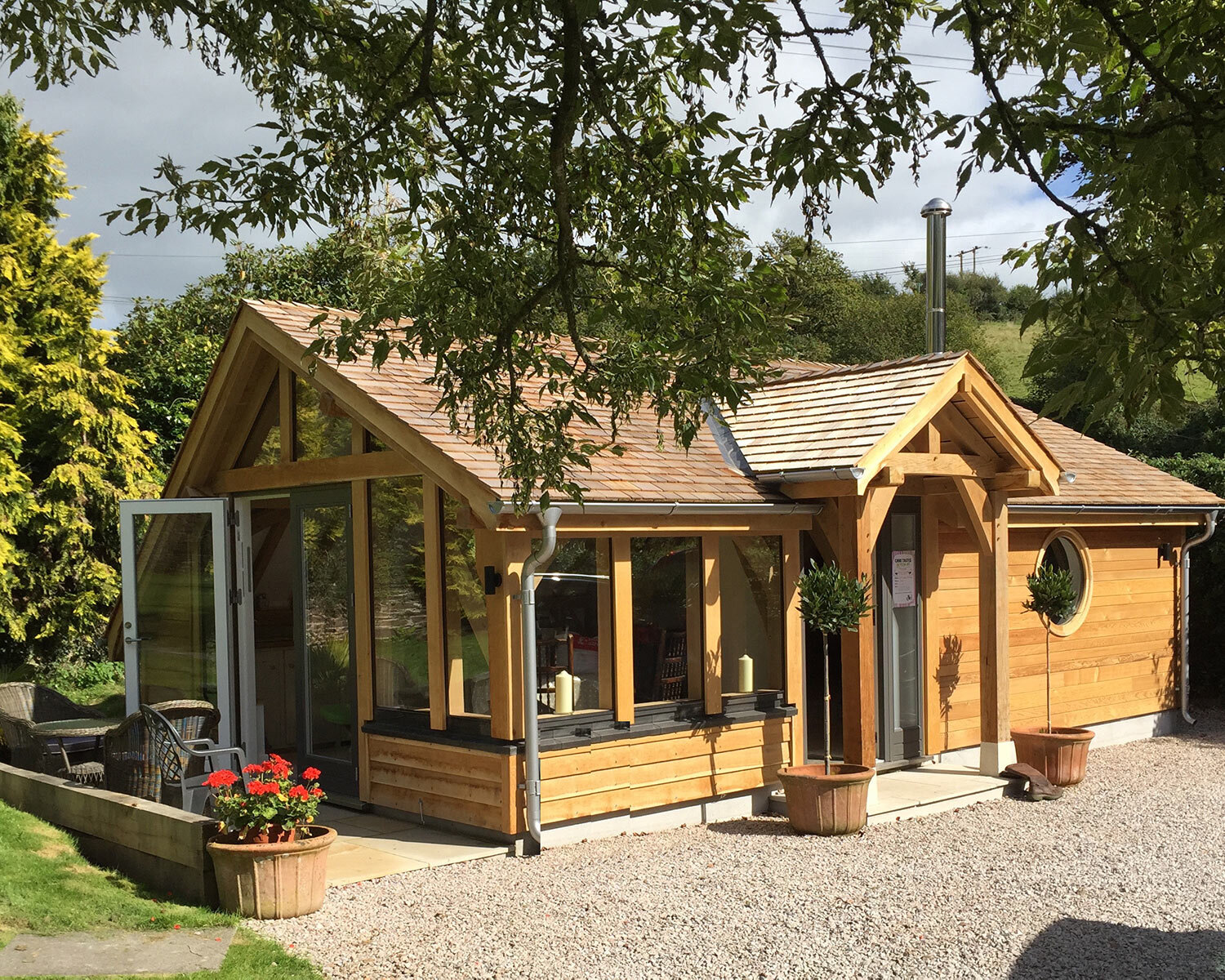 Oak-framed-lodge-cabin-with-porch-cedar-shingle-roof-providing-accommodation
