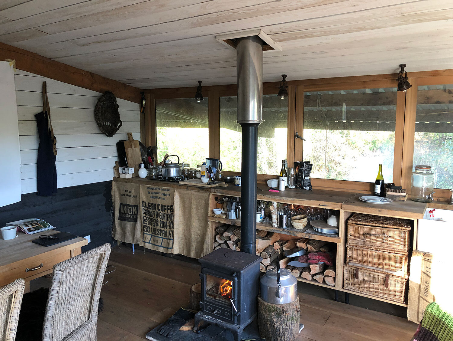 off-grid-rustic-cabin-interior-with-woodburner-and-handmade-kitchen