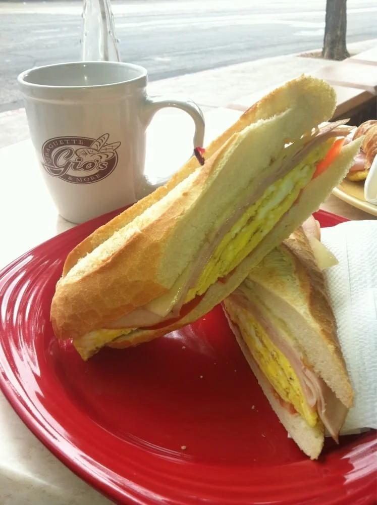 Model wearing light green backpack with black canvas straps and front zipper pouch.