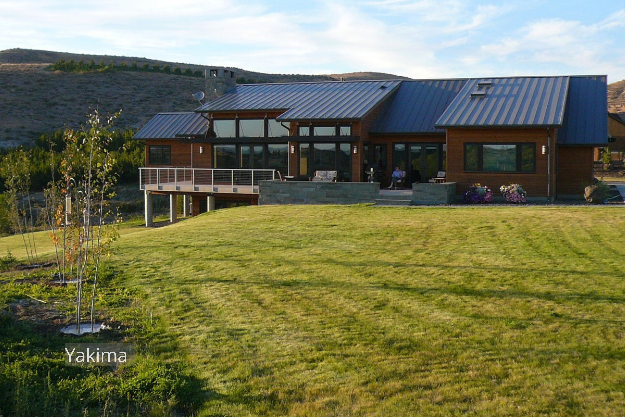 This Yakima-area residence sits in an open Eastern Washington landscape. Wood siding, a stone chimney, and an elevated deck give the home a strong connection to its setting.