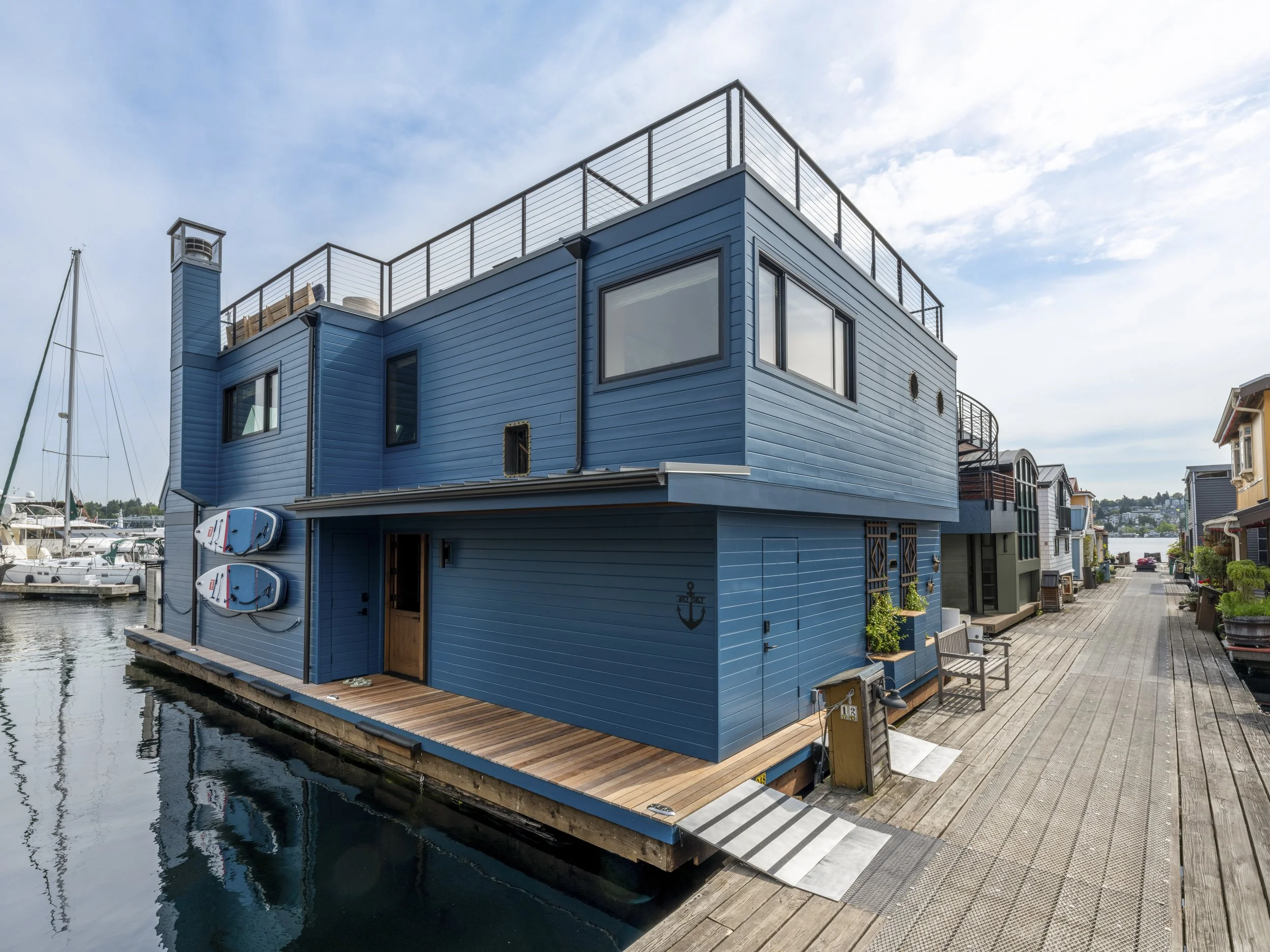 Nesika Chuck Floating Home | Seattle, WA

Dockside elevation highlighting bold blue siding, rooftop deck access, and contemporary floating home architecture along Lake Union.