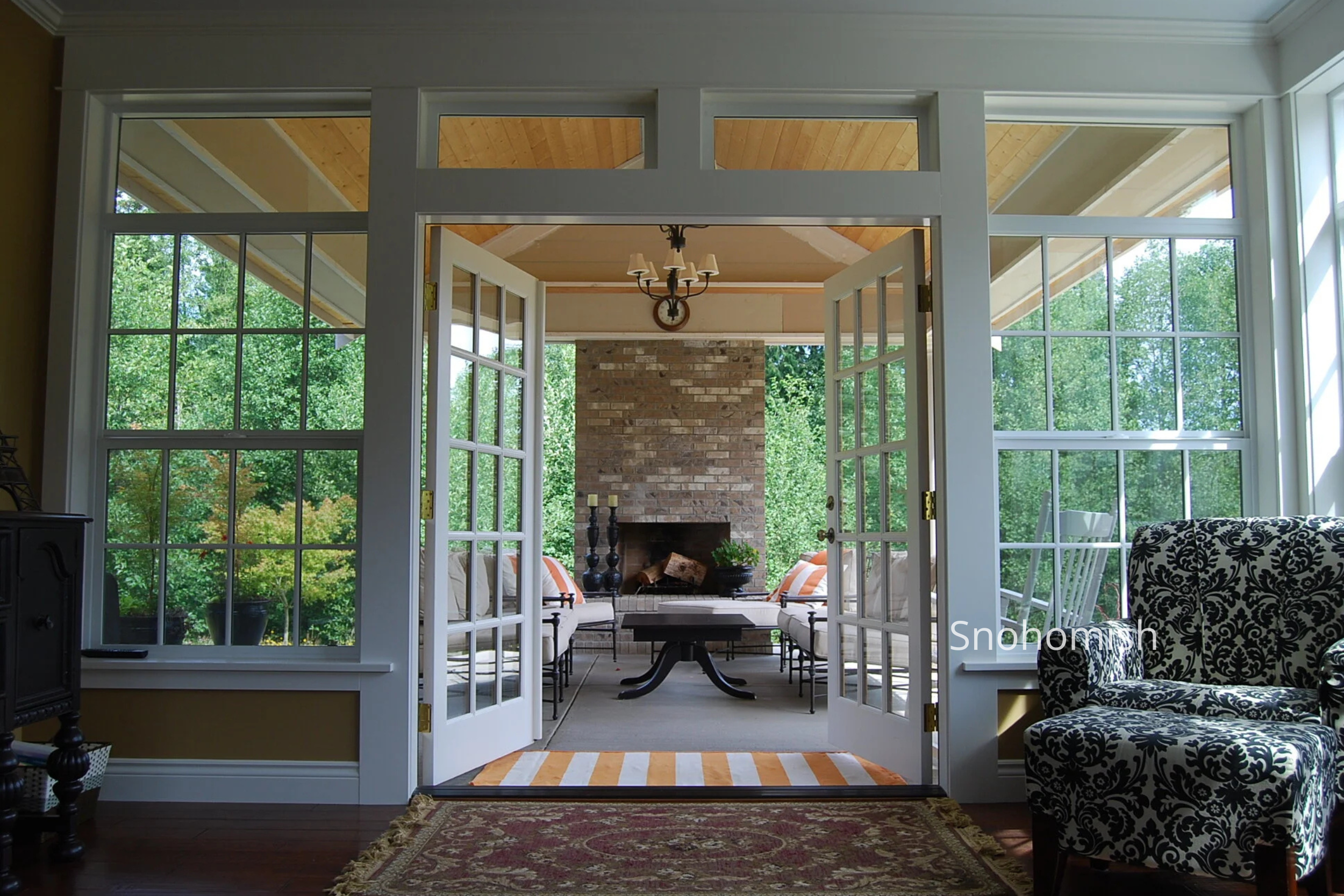 The Snohomish New Home is a custom colonial-style residence designed by ECCO Architecture on a nine-acre site of meadows and wetlands. The home was carefully oriented to capture views of a historic barn, valley, stream, and surrounding landscape, wit