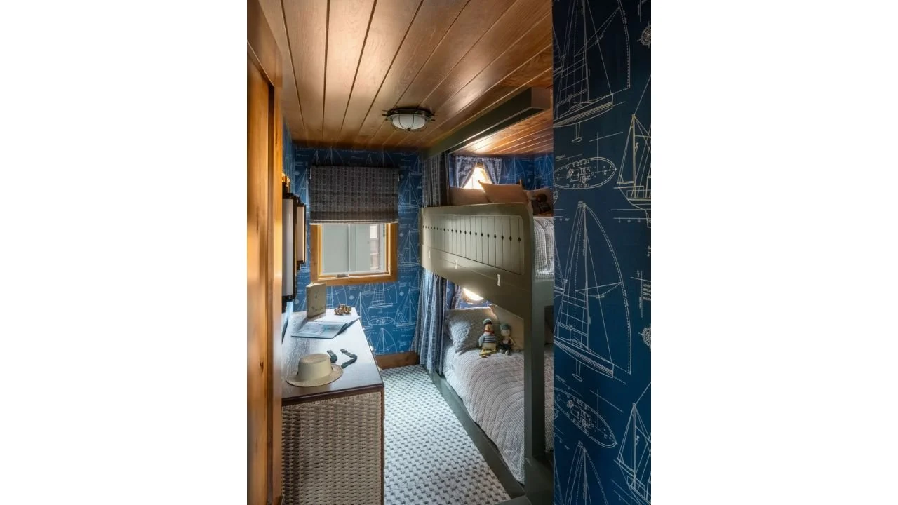 The Nesika Chuck bathroom combines a warm wood ceiling, rich blue surfaces, and carefully integrated storage within a compact footprint. Layered materials and thoughtful detailing give the floating home interior a cozy, distinctive character.