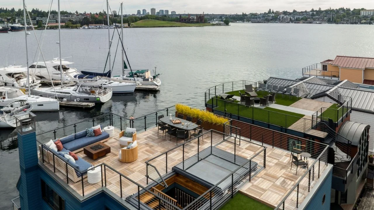 The Nesika Chuck rooftop deck offers generous lounge and dining areas overlooking the marina and surrounding water. Railings preserve open views while planted areas and comfortable furnishings create an elevated outdoor room for relaxing and entertai