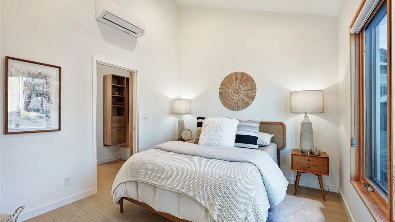 A serene bedroom in the Furhman Floating Home with soft neutral finishes, warm wood detailing, and natural light. The room reflects the home’s quiet, modern character and provides a restful private retreat.