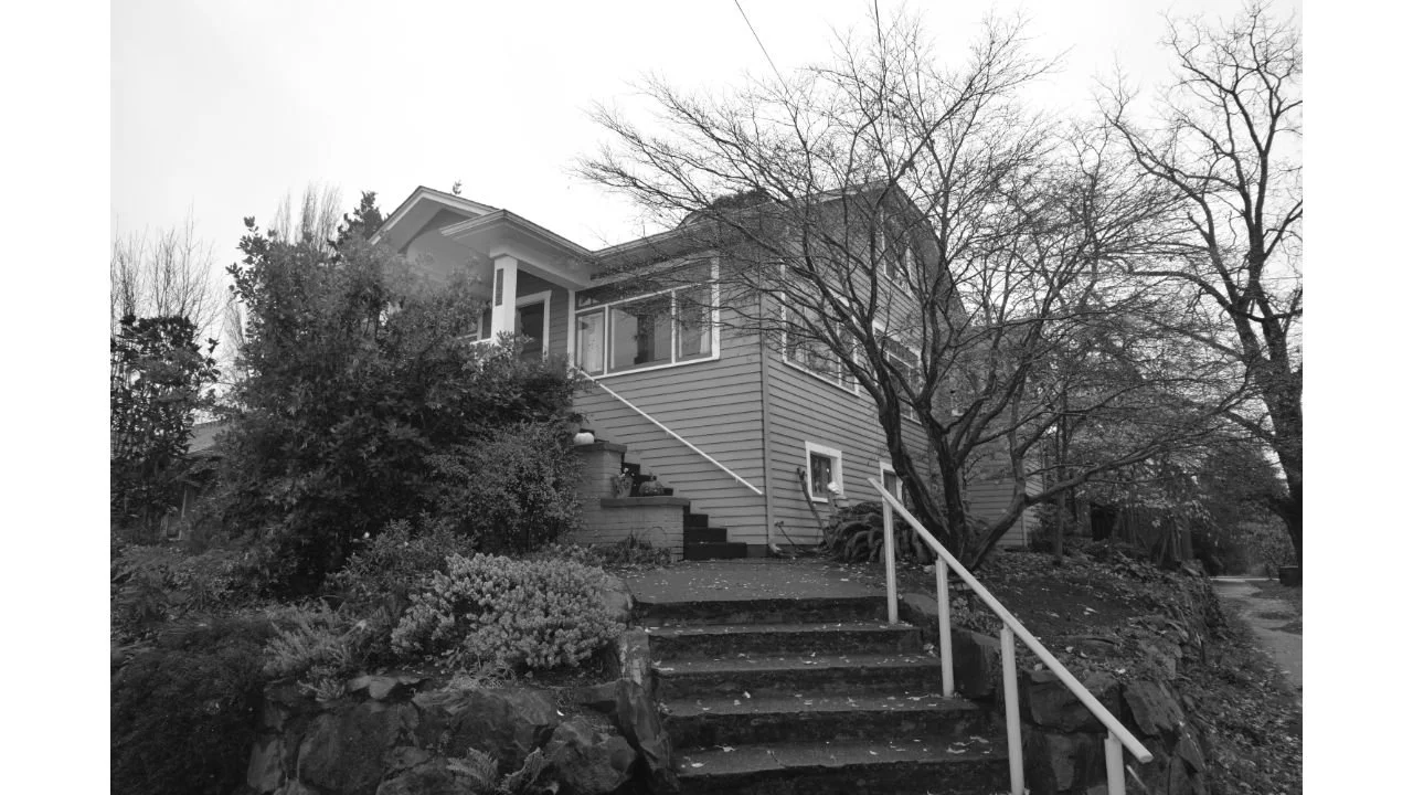 Black-and-white view of the original Phinney Ridge home before the second-story addition and remodel. The existing upper level had low, sloping ceilings that limited usable space and shaped the need for a more functional full second floor.