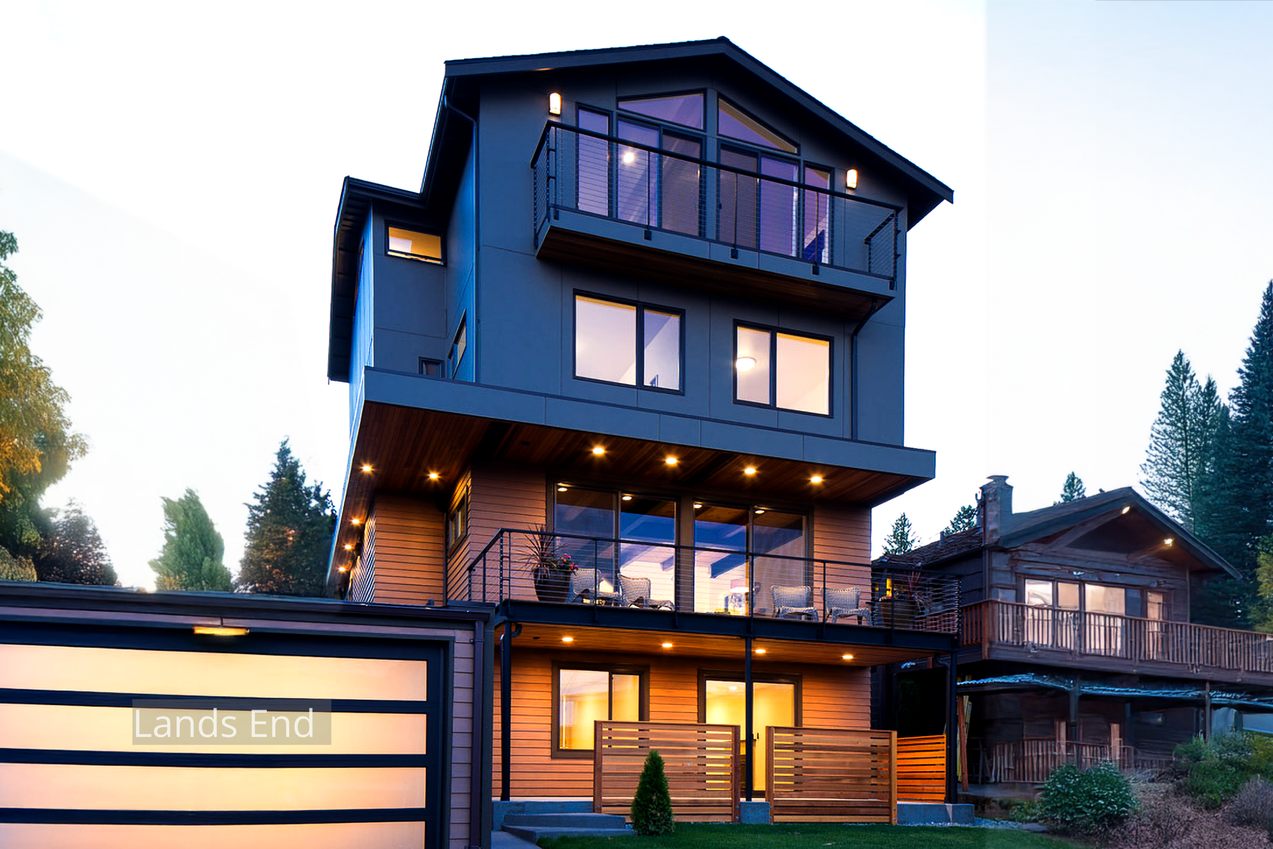 Evening view of the Lands End Remodel, a four-level modern home overlooking Salmon Bay. ECCO Architecture transformed a modest single-story structure into a contemporary residence featuring open-plan living, expansive glazing, and a top-floor master 