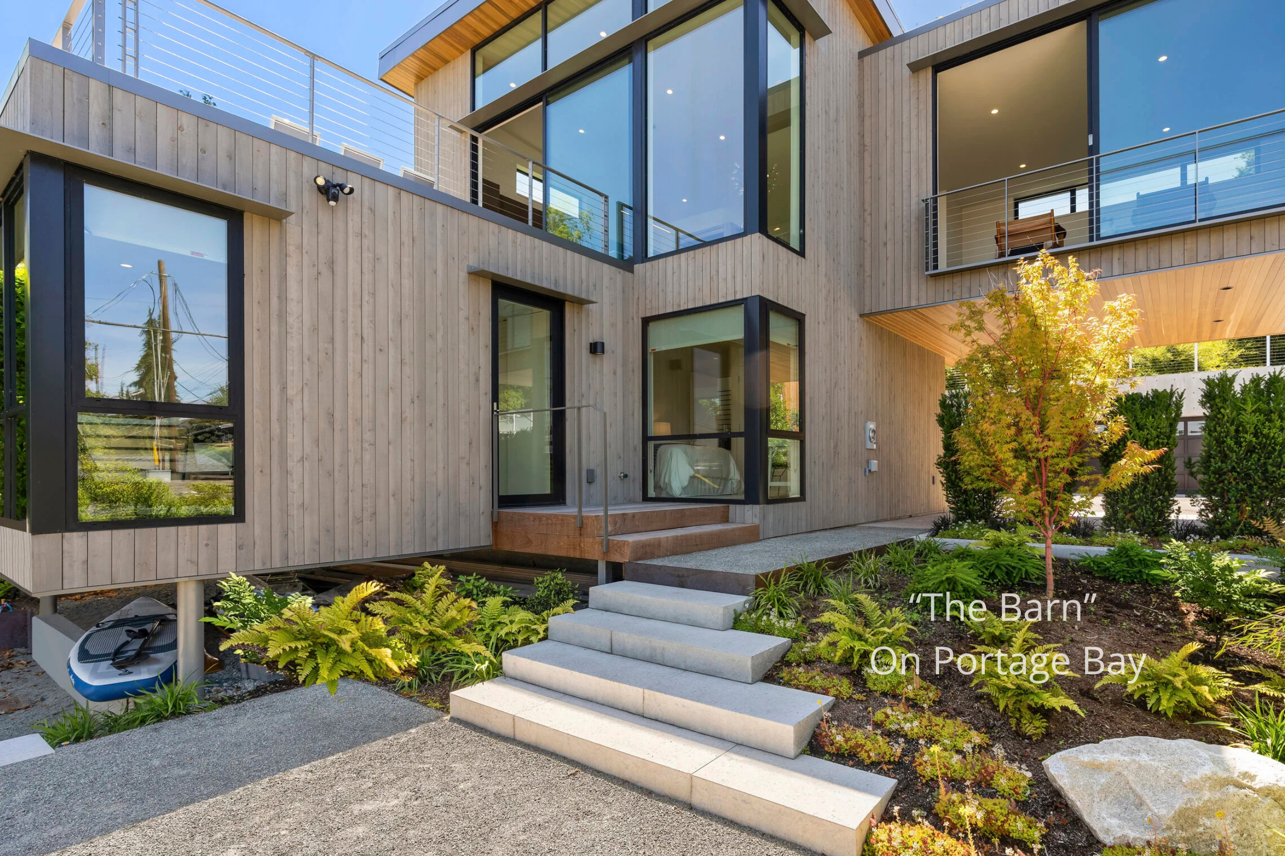 Modern waterfront home on Portage Bay blending barn-inspired architecture with contemporary design, expansive glazing, and seamless indoor-outdoor living.