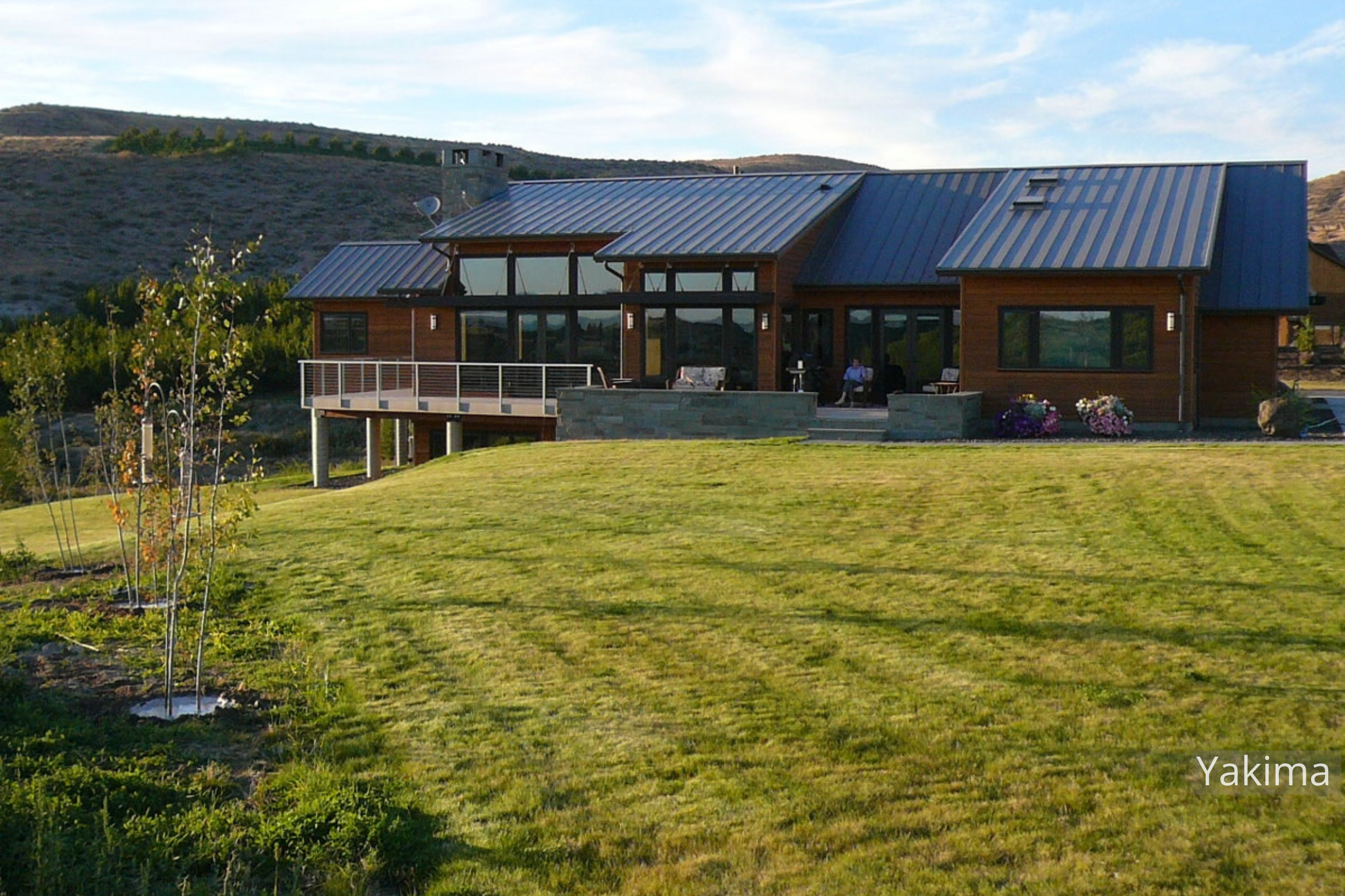 This Yakima-area residence sits in an open Eastern Washington landscape. Wood siding, a stone chimney, and an elevated deck give the home a strong connection to its setting.