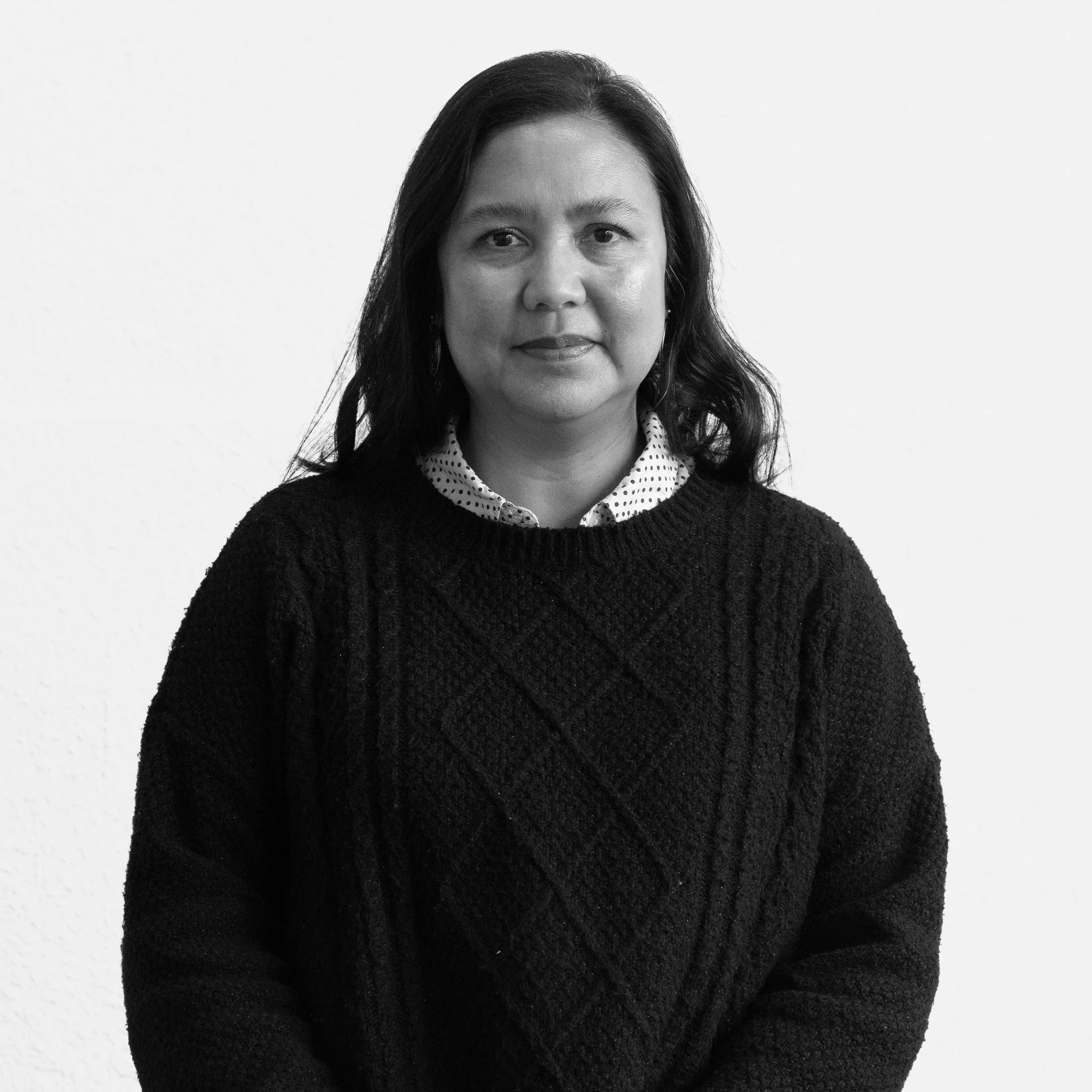 Black and white portrait of Leila Pasco smiling at the camera against a plain white background.