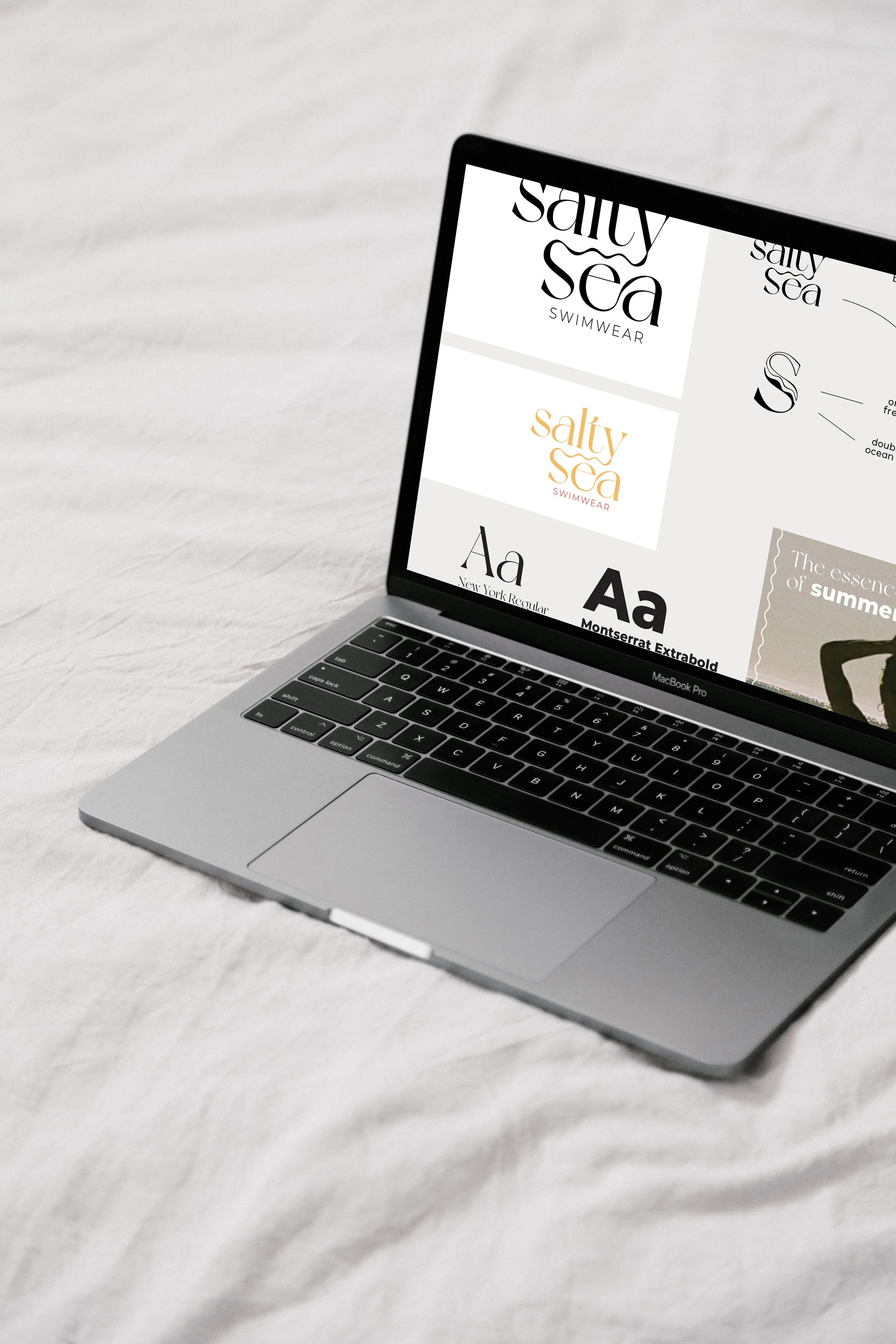 MacBook Pro displaying swimwear brand logos and typography options on a bed.