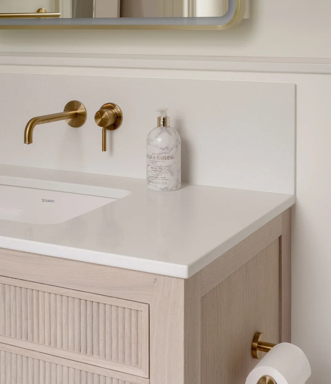 Bespoke bathroom vanity with fluted drawer fronts, quartz surface and brass cabinet hardware