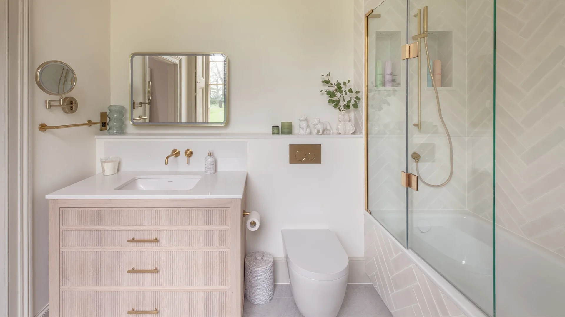 Luxury ensuite bathroom with warm white palette, detailed herringbone tiling and brushed brass accents