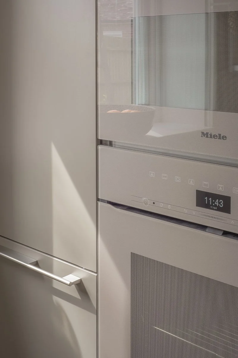 Miele ovens in pearl beige integrated into Bulthaup kitchen tall units at eye level