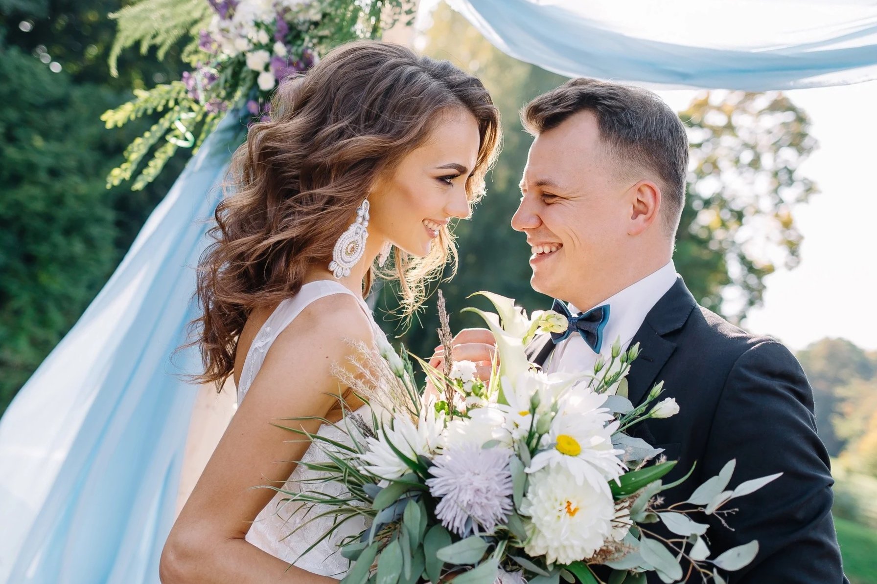 Springfield, il wedding couple on the lake. Bride is holding blue and white bouquet of flowers.