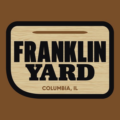 Logo of Franklin Yard, Columbia, IL, with bold black text on a wooden plaque background, surrounded by a dark border.