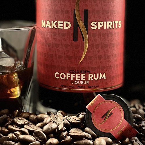 Bottle of Naked Spirits Cold Brew Coffee Rum with a glass, surrounded by coffee beans.