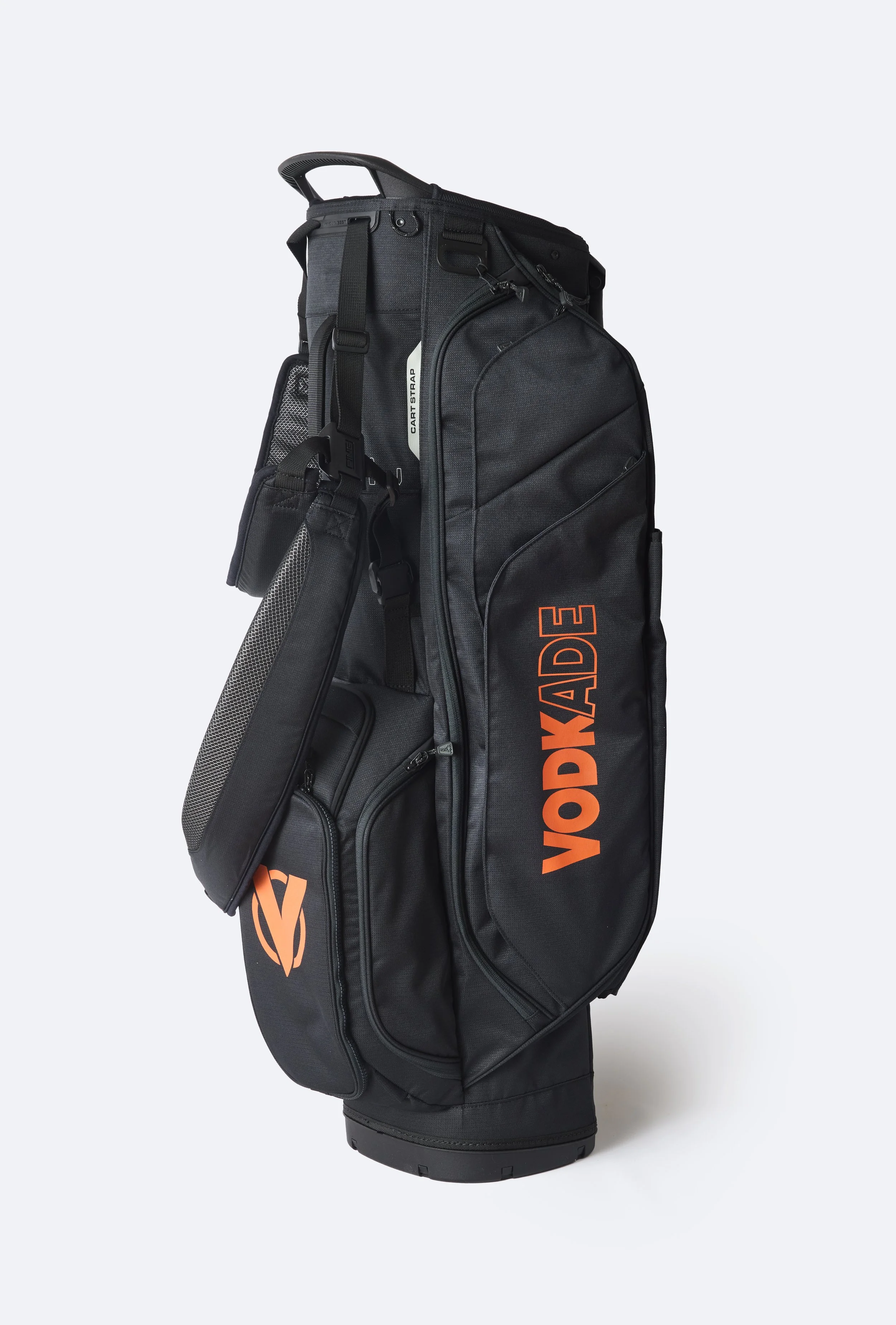 A black golf bag with orange 'Vodkade' branding, standing upright on a white background, featuring multiple zippers, compartments, and a strap.