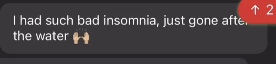 Text message on a dark background that reads, "I had such bad insomnia, just gone after the water" with two hands raised in a praying or thankful gesture.