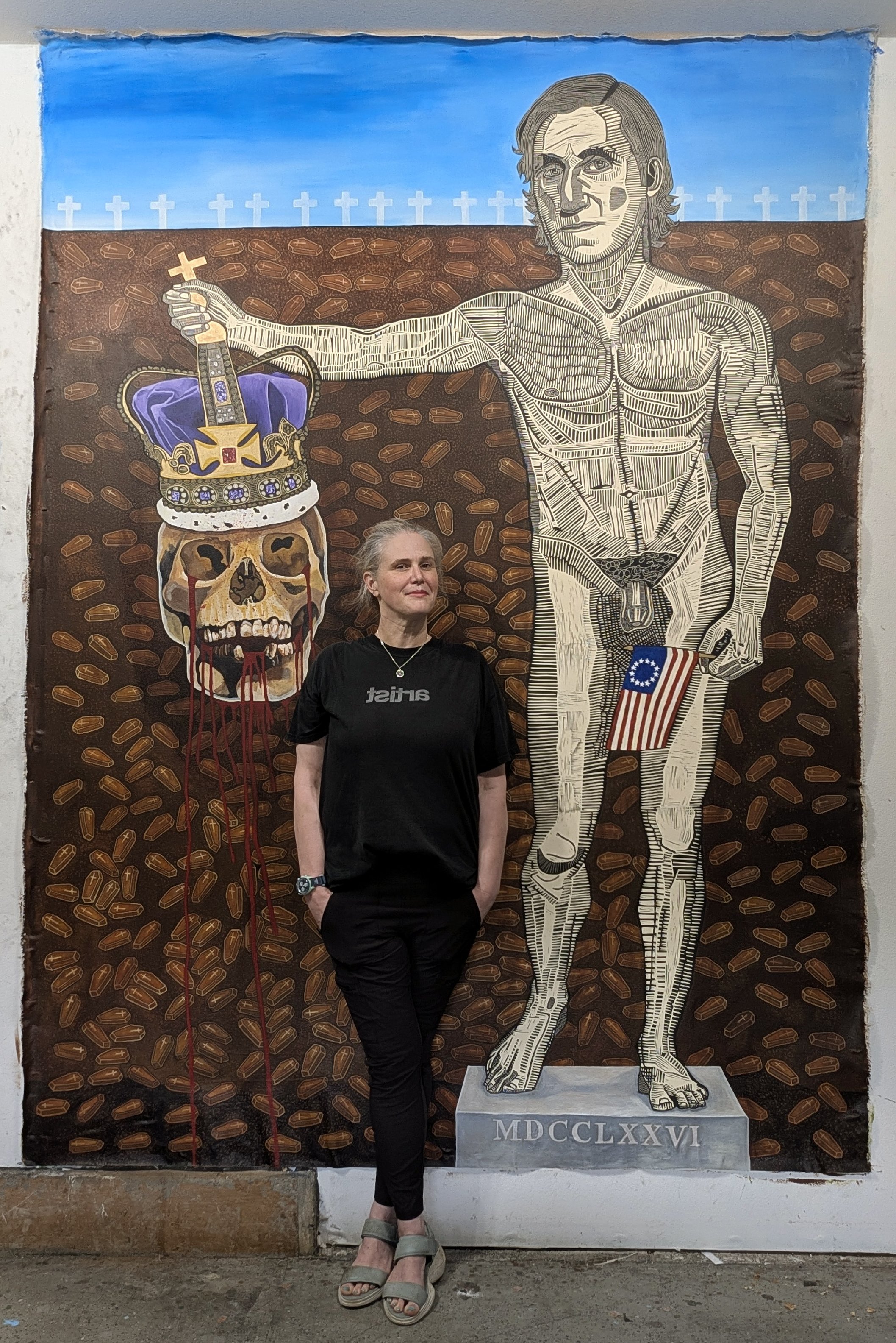 Artist Valerie Wallace standing in front of her linocut painting of a nude George Washington.  This piece is about the Revolutionary War.