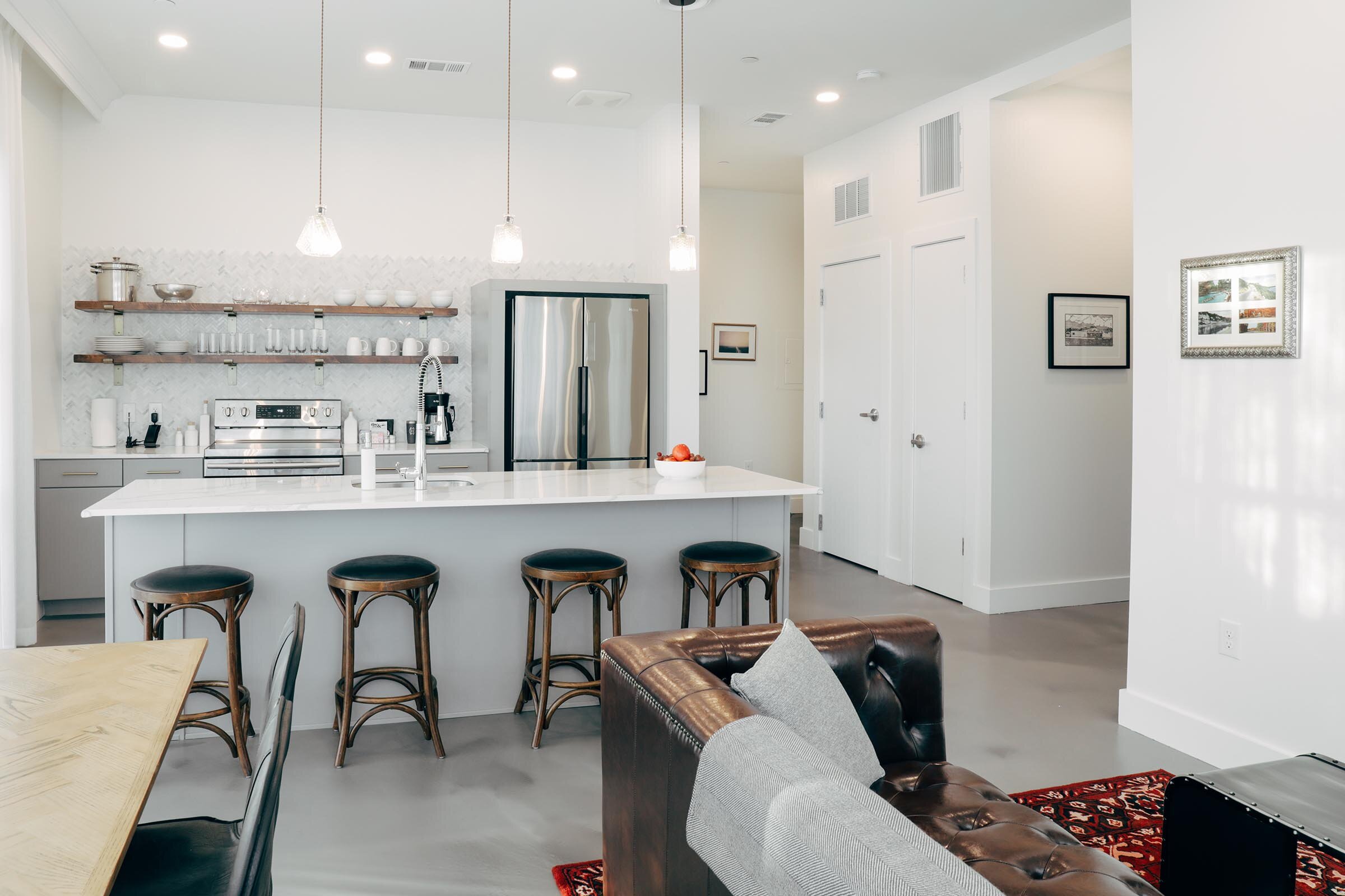 kitchen with breakfast bar and stools, partial view of dining table, living area