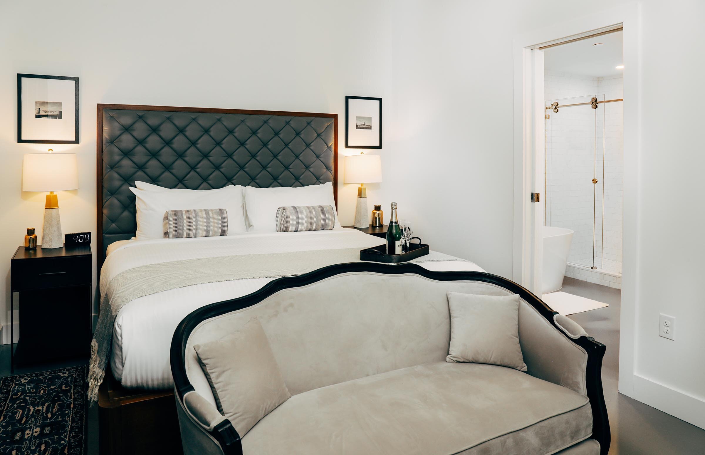 master bedroom with settee at foot of king bed, en suite bathroom (Copy)
