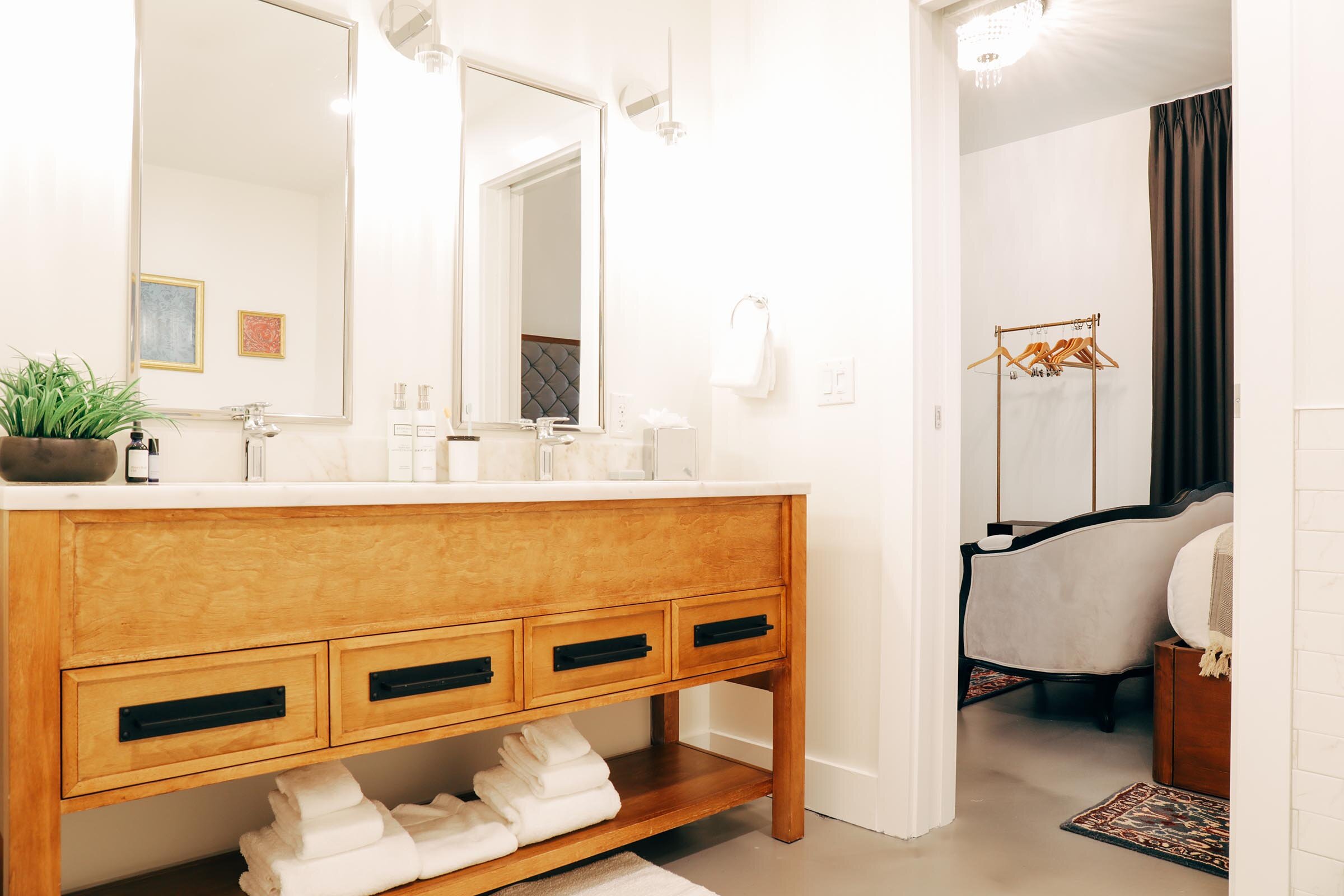en suite bathroom with double sink vanity, wooden drawers, white countertop (Copy)