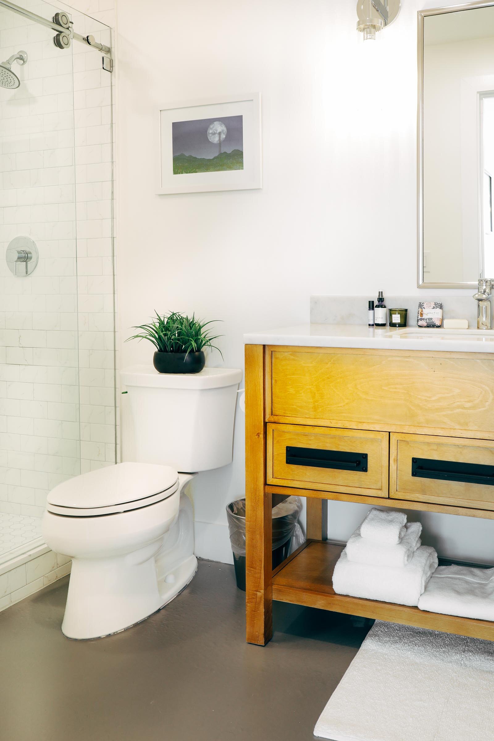 toilet next to walk-in shower, double sink vanity