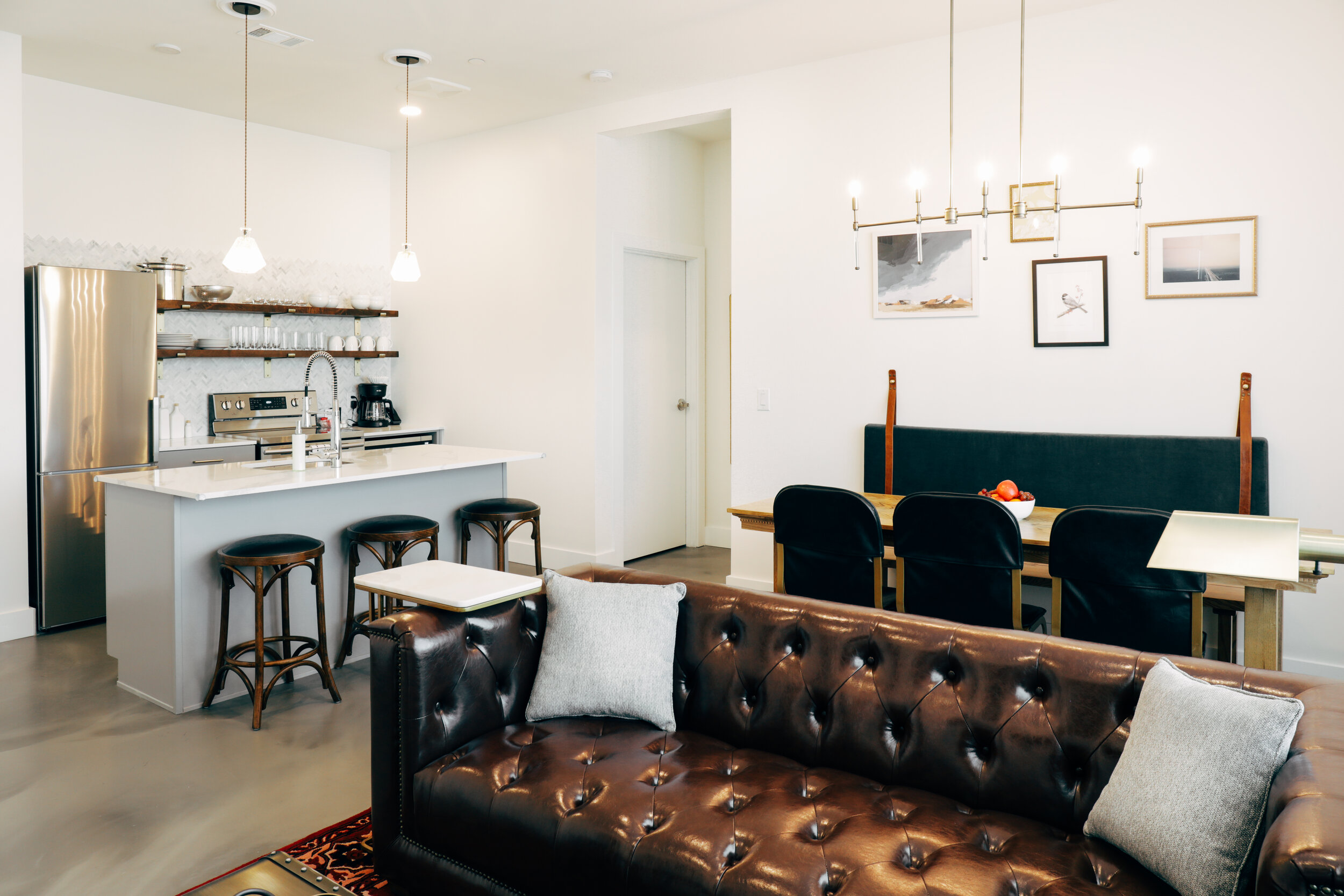 kitchen with breakfast bar, dining table, and living area with couch 