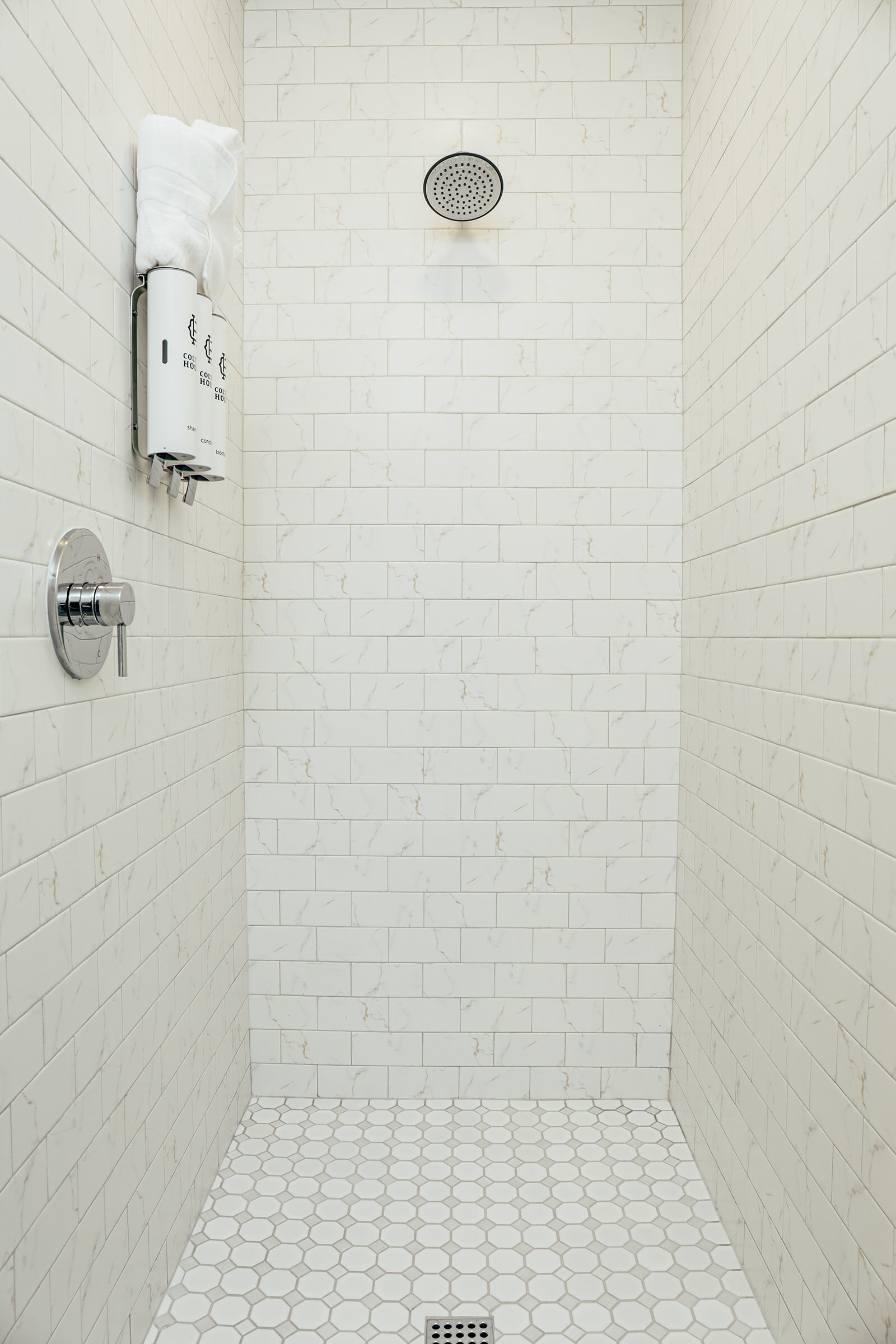 walk-in shower with white tiles