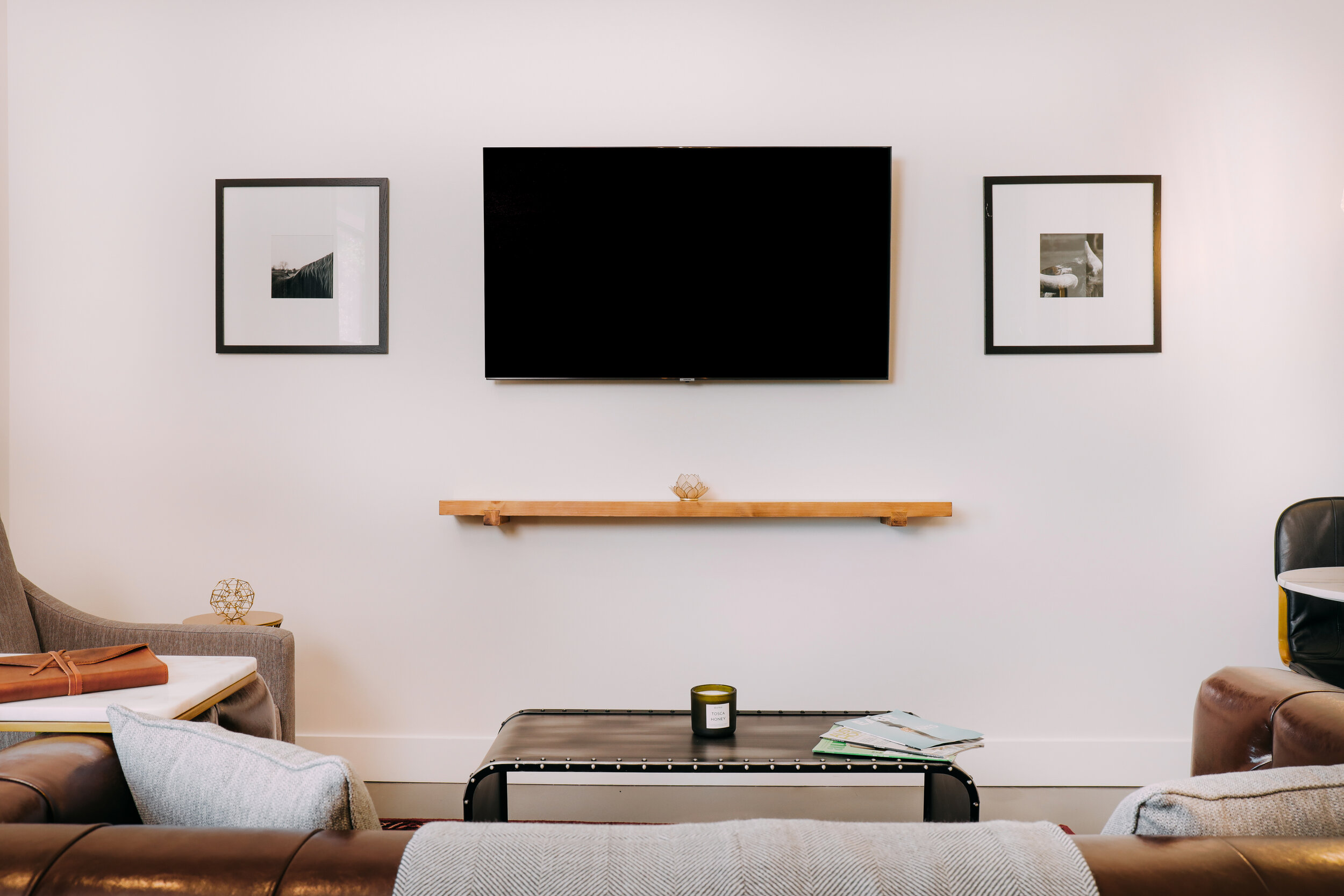 tv mounted on wall, couch, coffee table, and chair