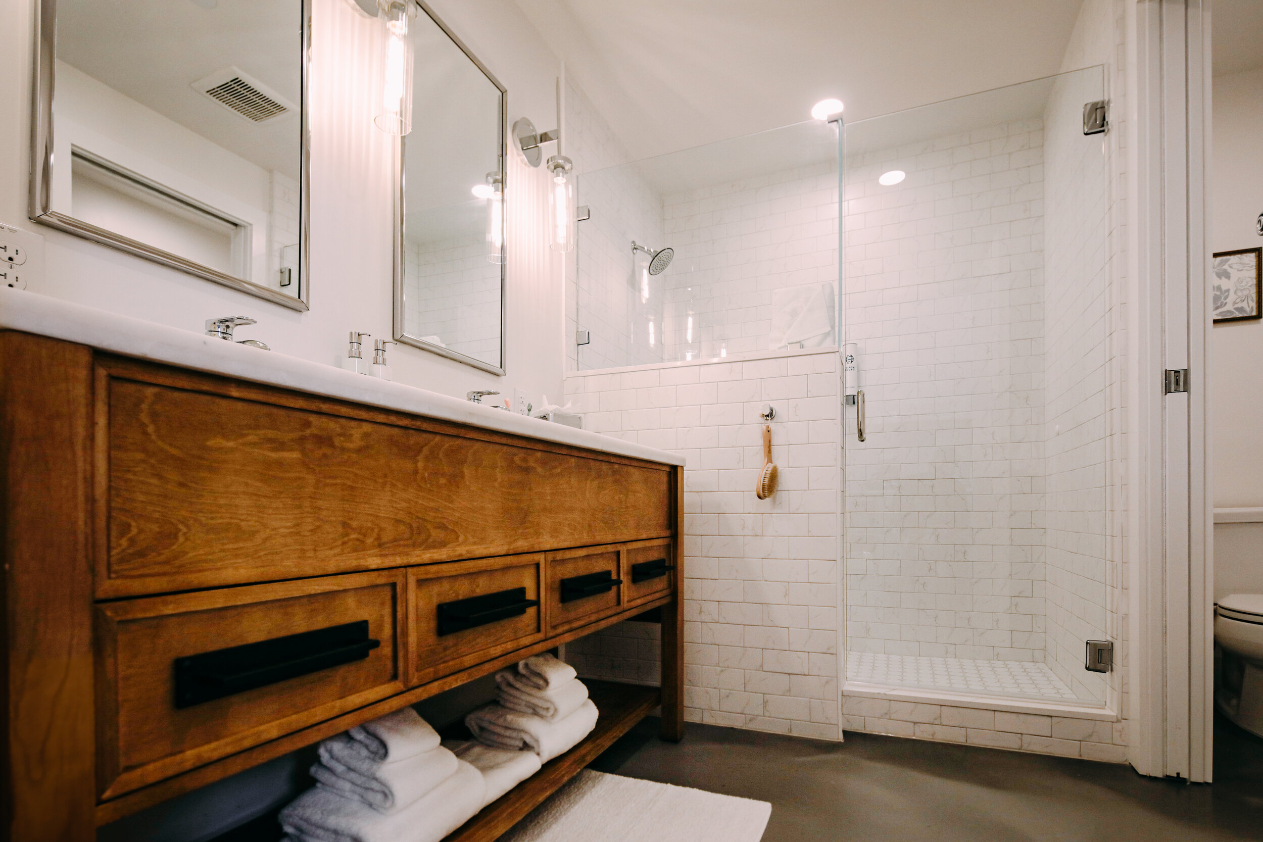 walk-in shower, double sink vanity, white towels