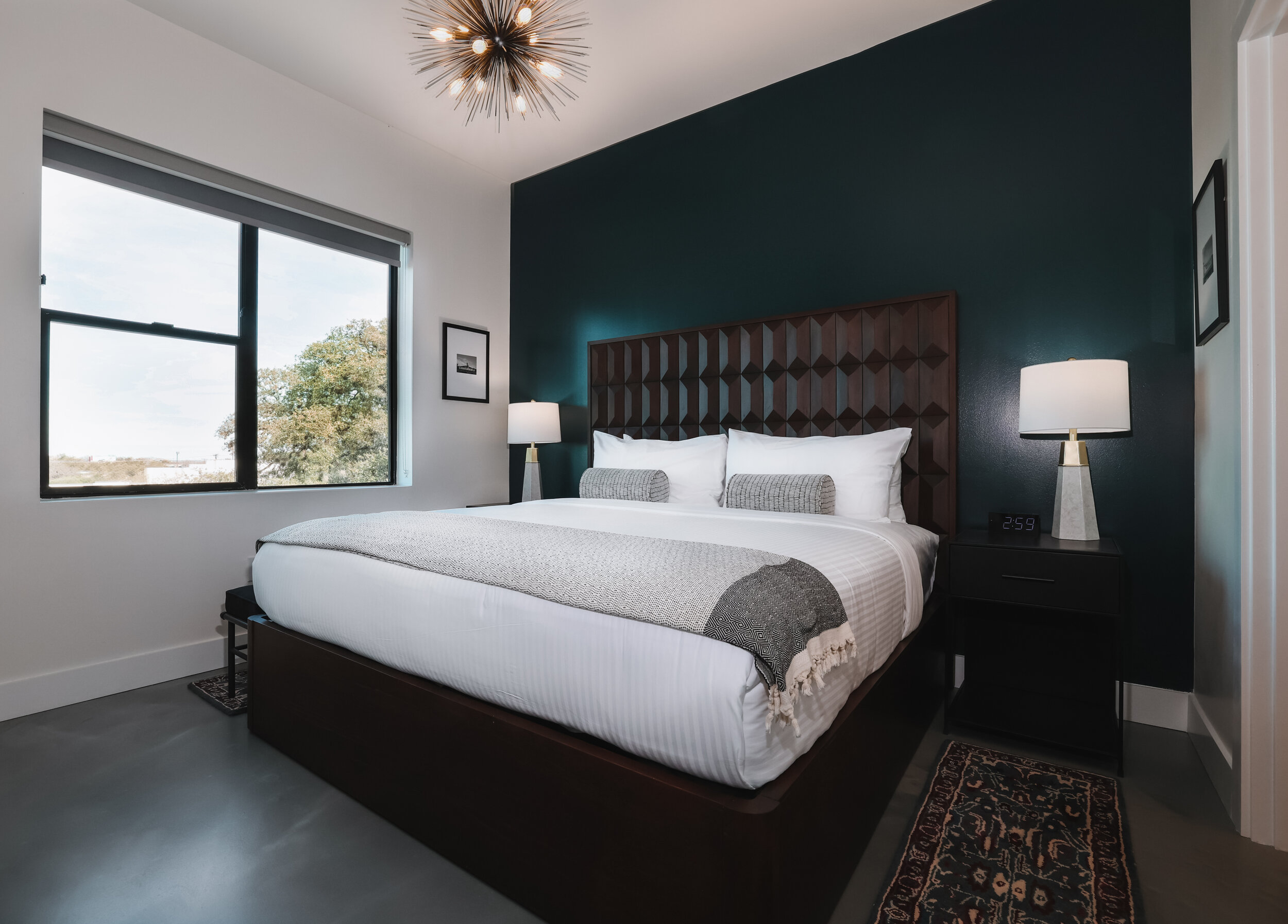 king bed in master bedroom against dark blue accent wall