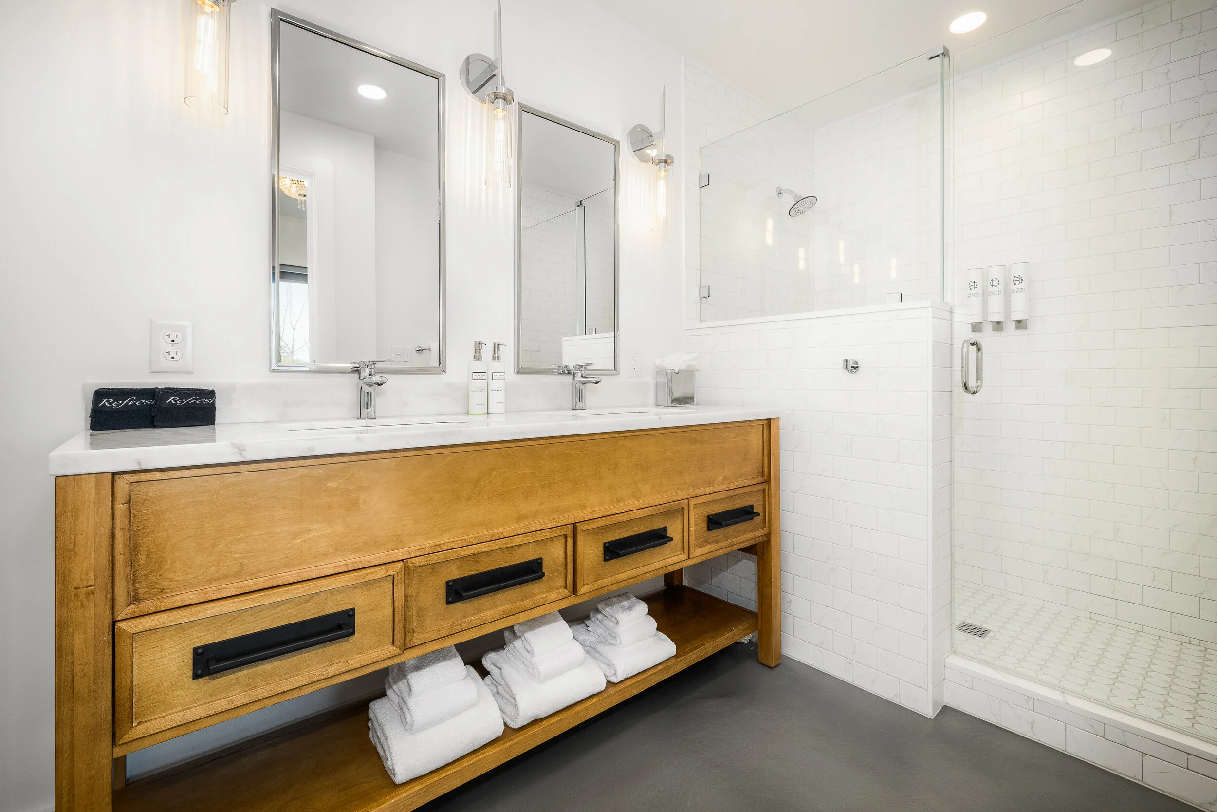 double sink vanity, wooden drawers, walk-in shower with glass door