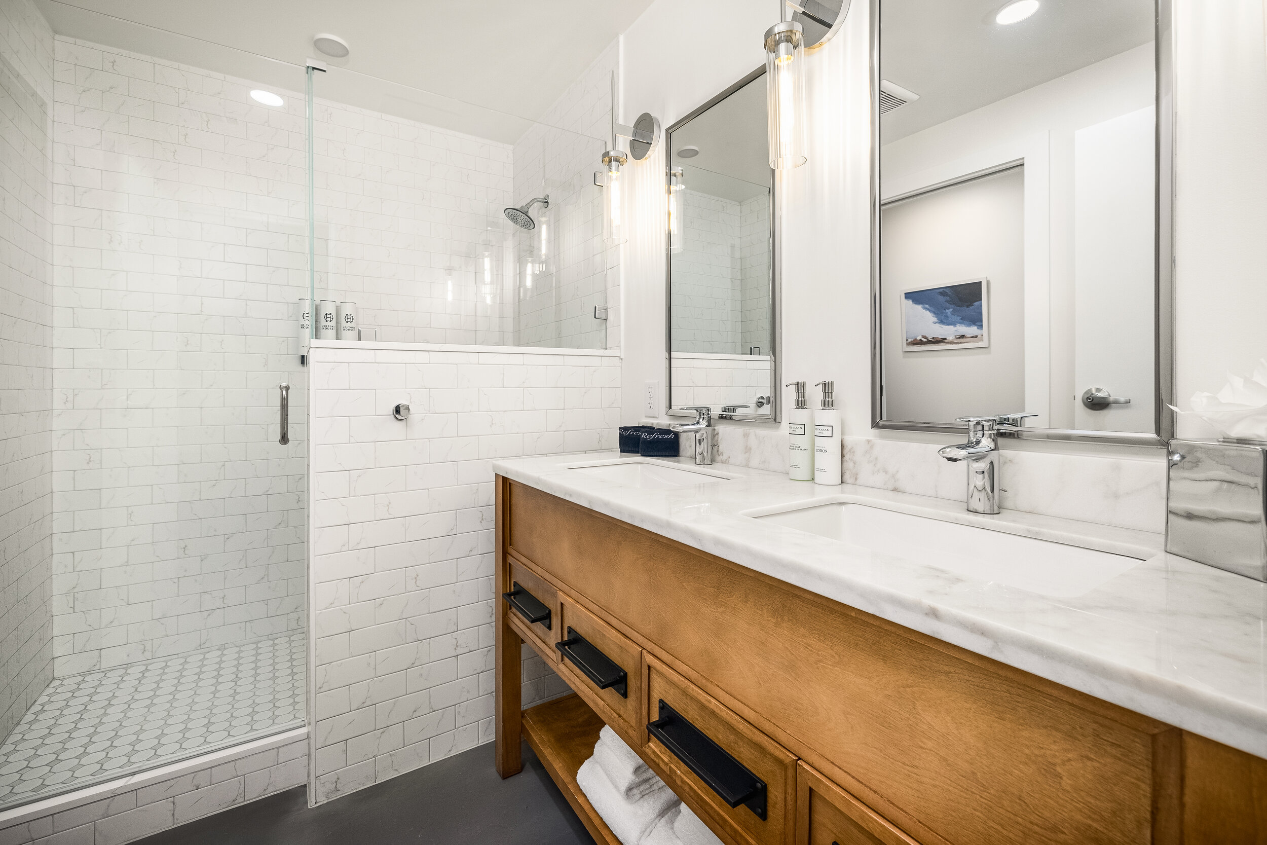 double sink vanity, wooden drawers, walk-in shower with glass door