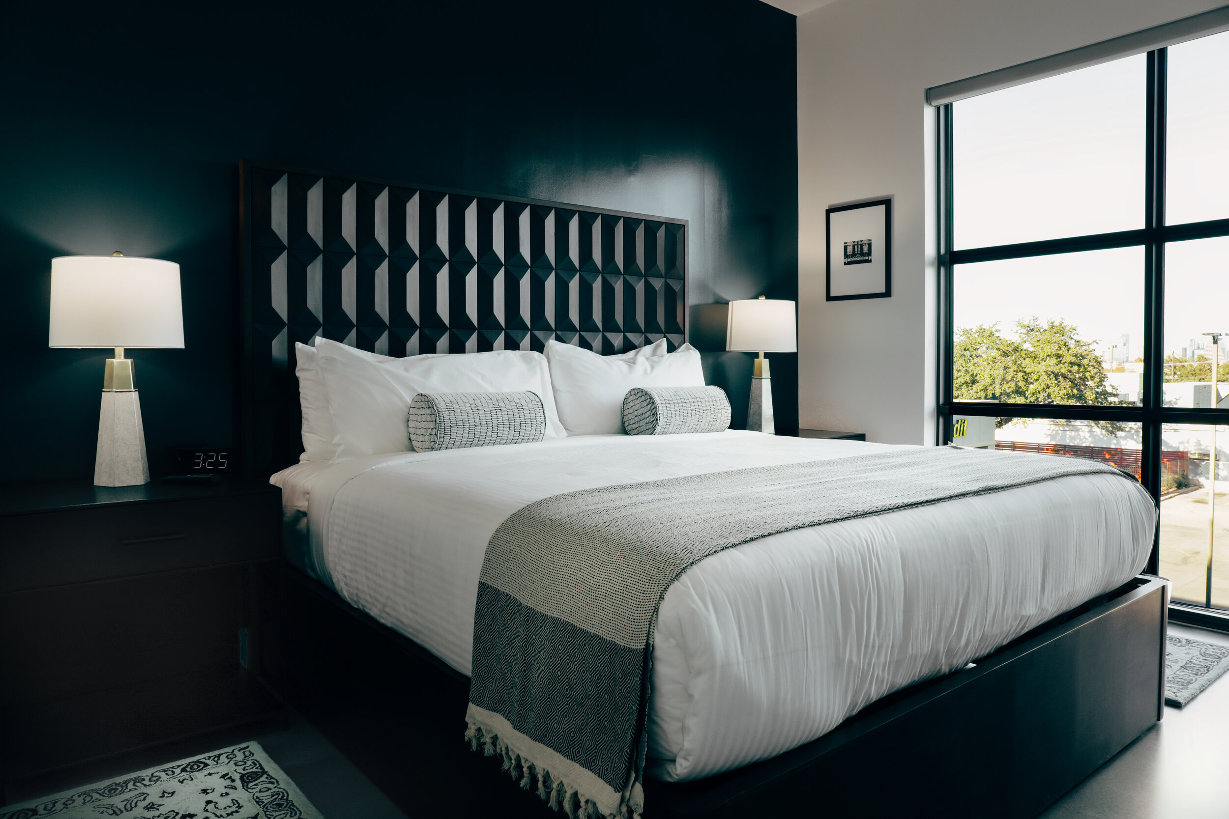 king bed, wooden headboard against blue wall. bedside lamps