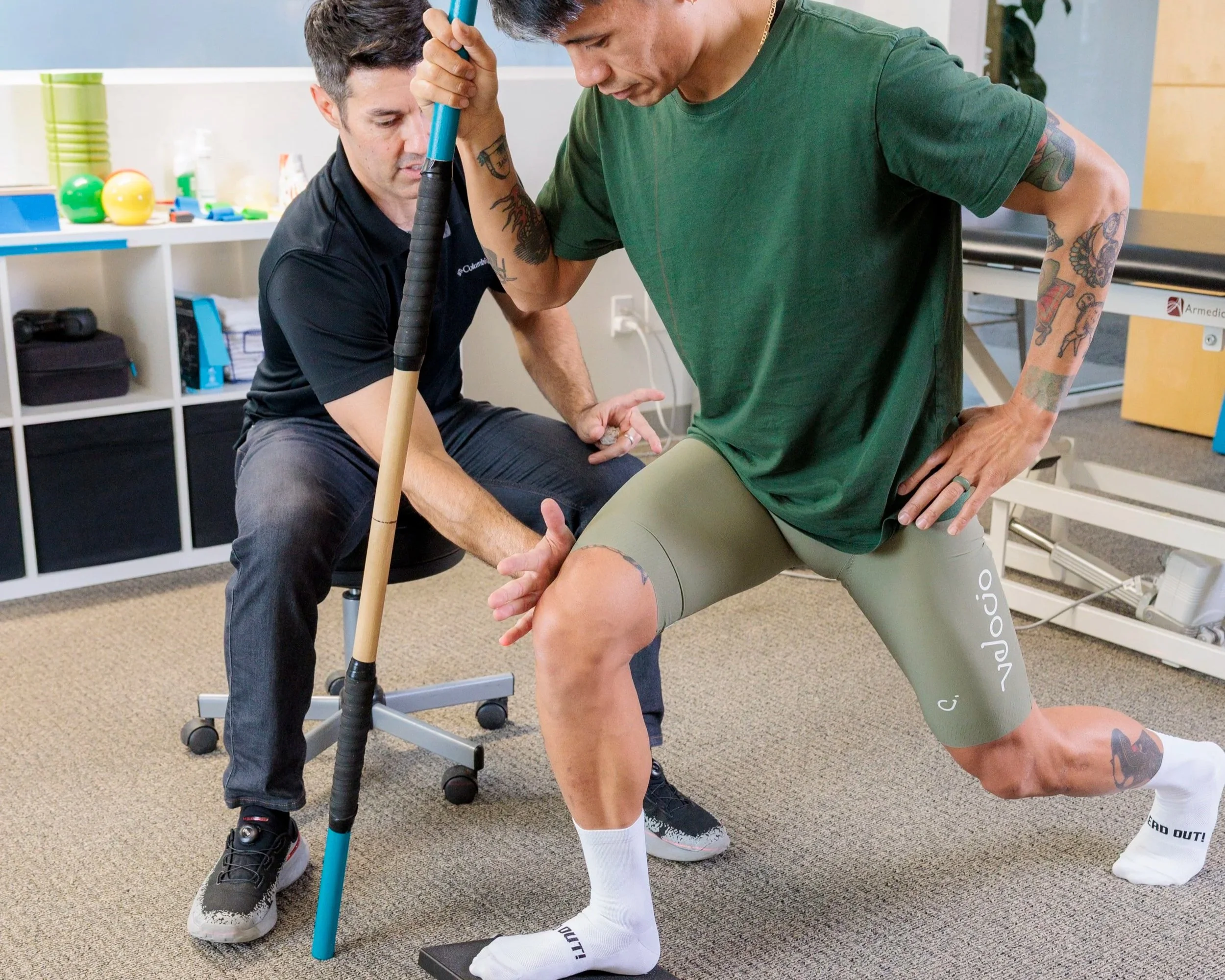 Physical therapy client on table doing a hip bridge with Physical Therapist at their feet.